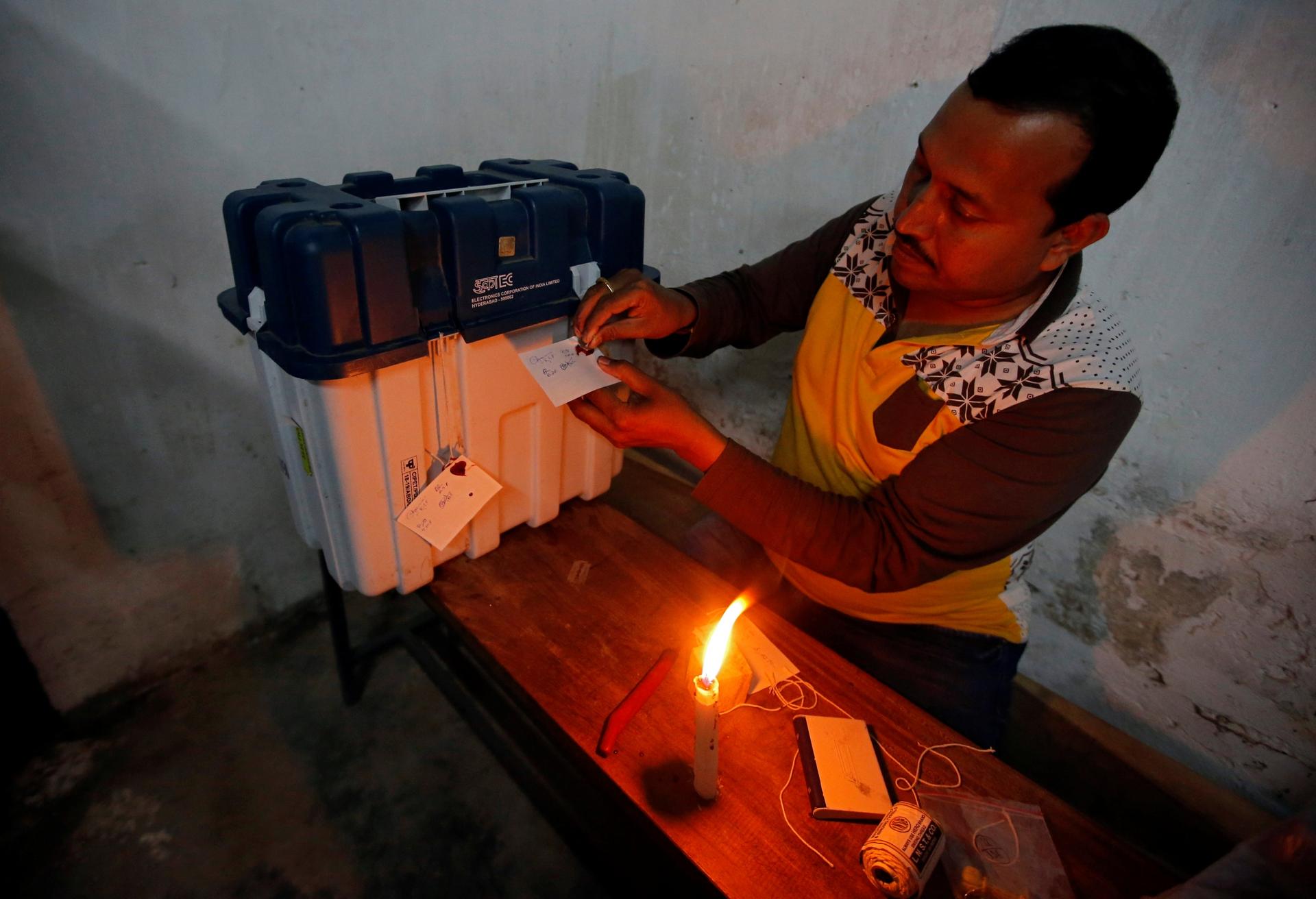 a voting official seals a ballot in india