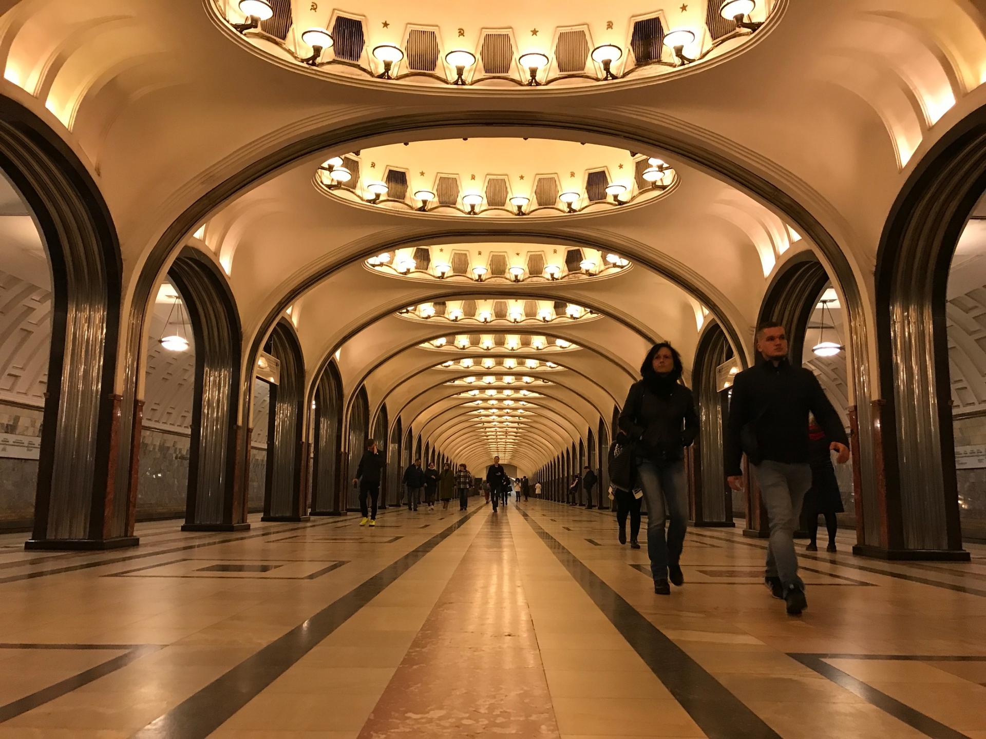 People walk through a gleaming train station 