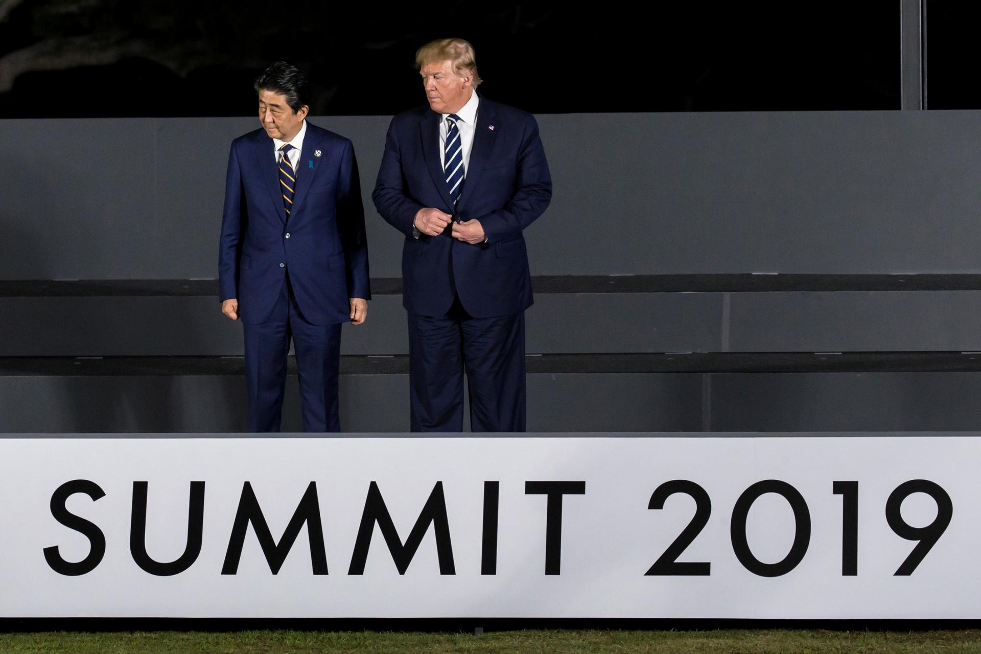 US President Donald Trump stands with Japanese Prime Minister Shinzō Abe above a sign that says Summit 2019