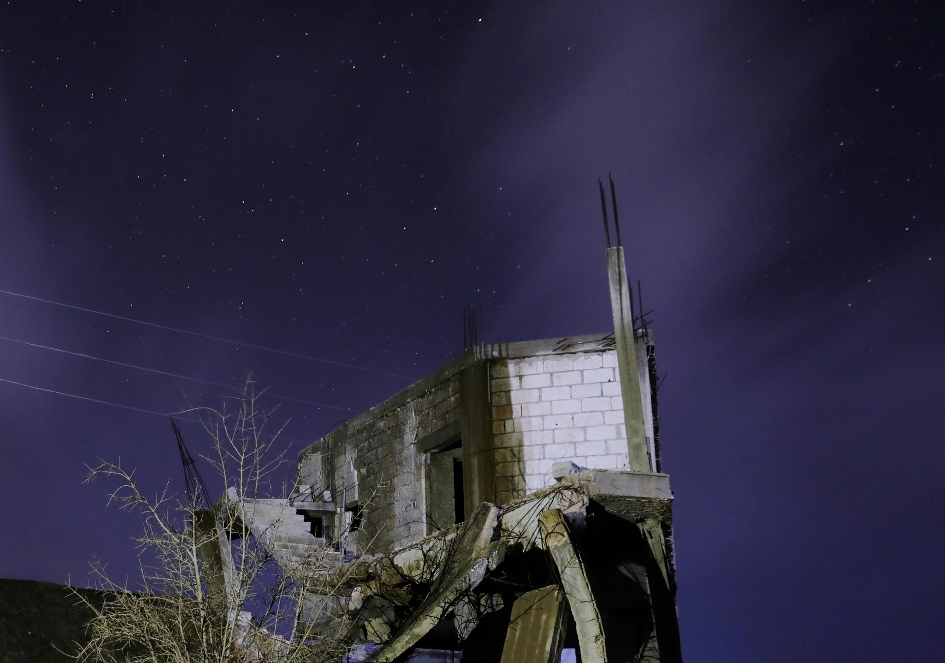 Destroyed home against dark blue night sky