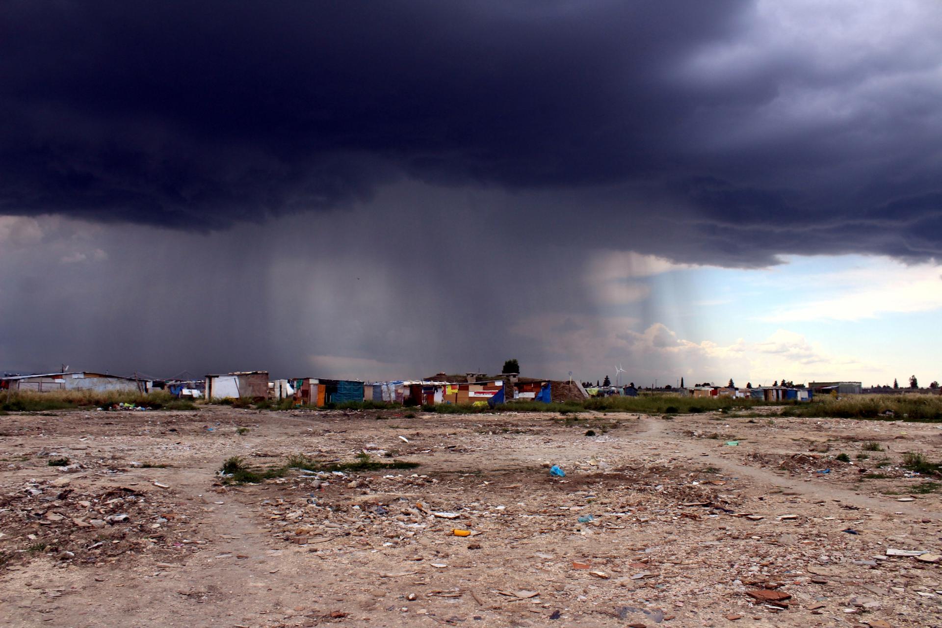 Storm clouds gather over the "ghetto" where migrants live