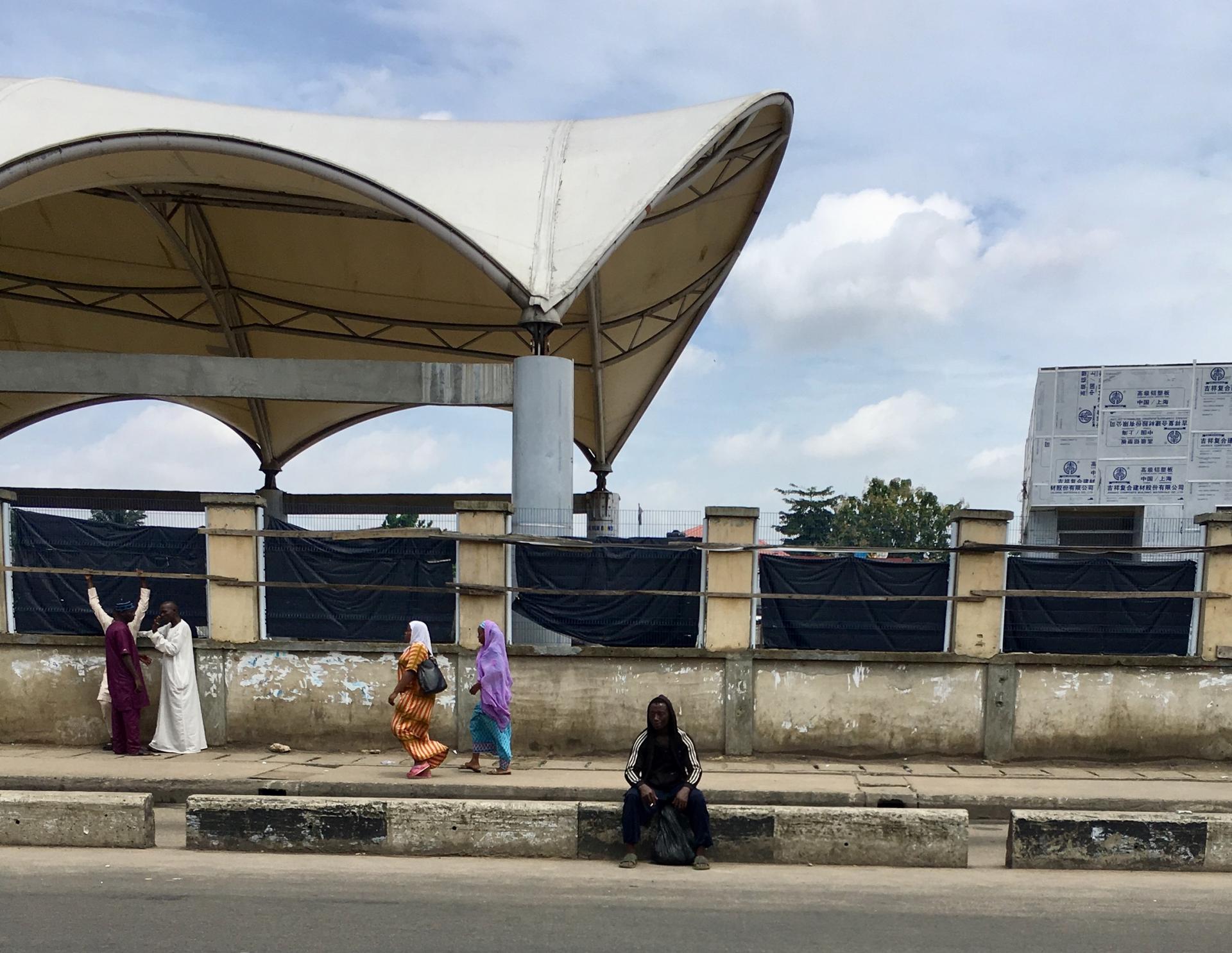 A mentally unstable man sits at a bus stop nearby the hospital