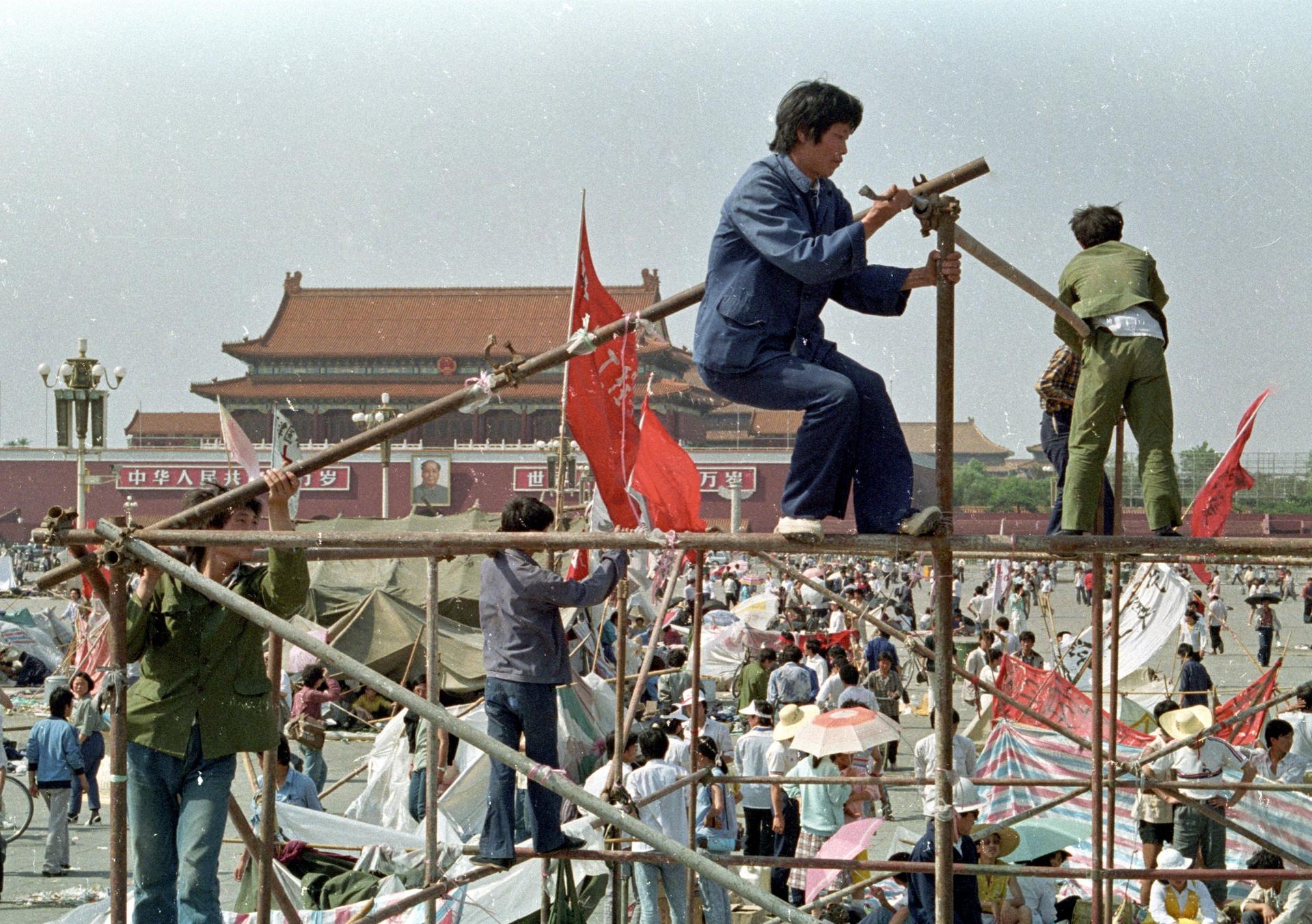 Students prop up wooden poles to build tents in Tiananmen Square.