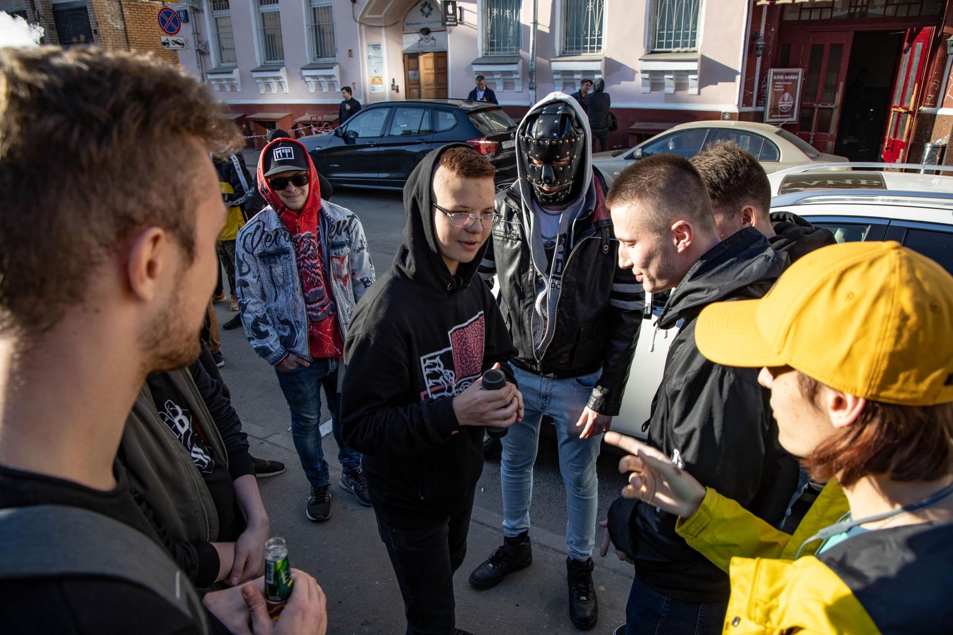 Young men talk outside while preparing for a rap battle. 