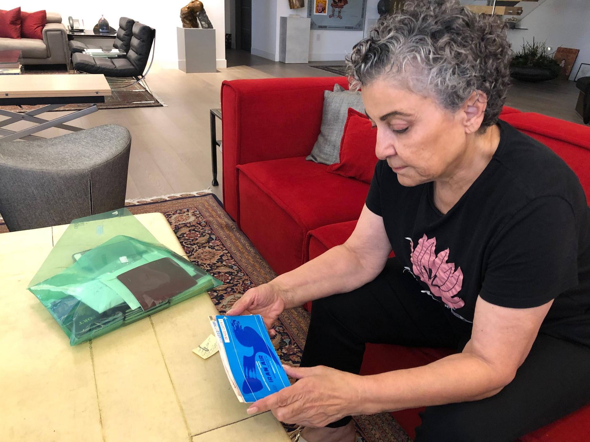 Iranian American radio host Homa Sarshar at her home in Los Angeles. She holds the plane ticket that brought her to the US more than 40 years ago.