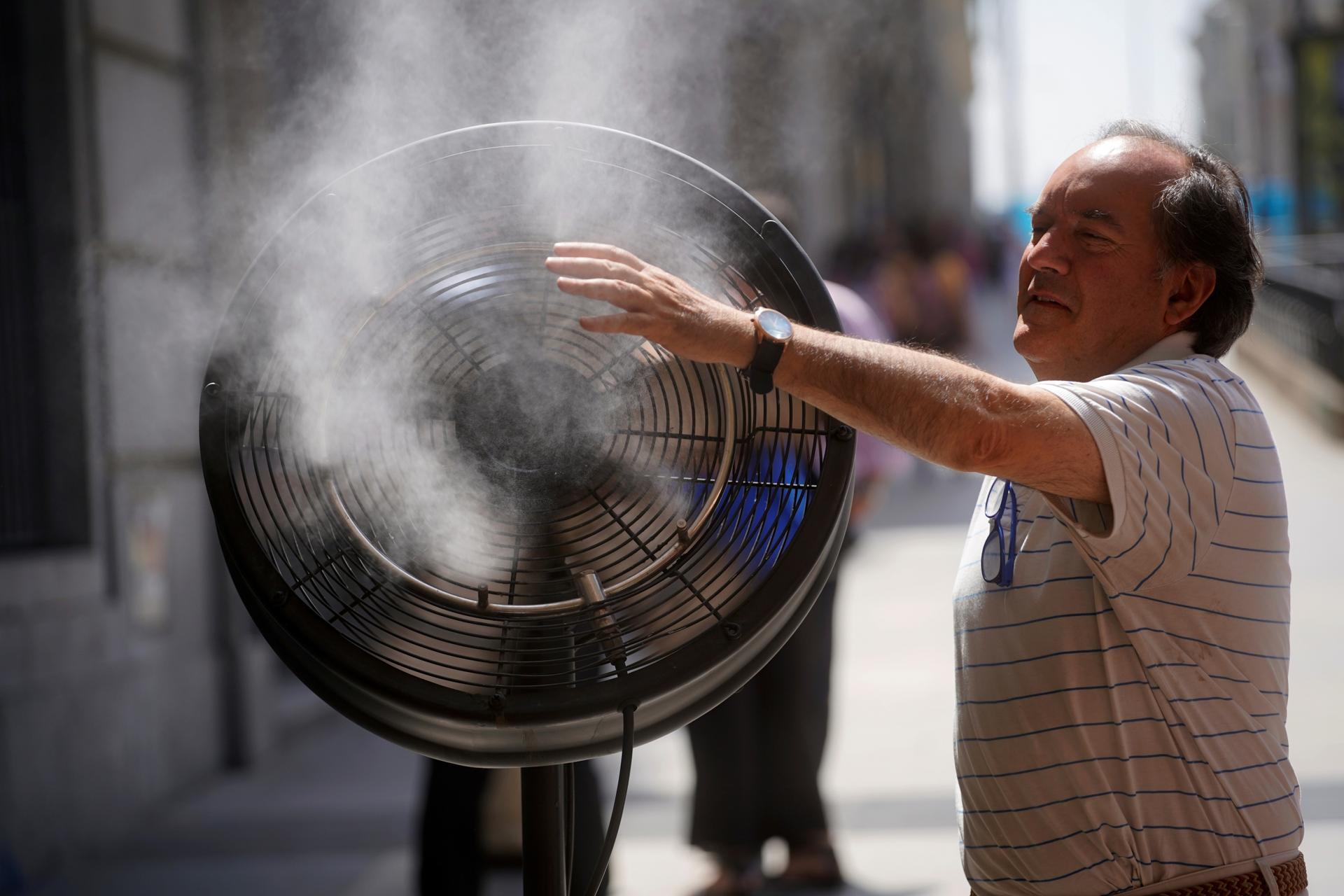 Man cools himself down with huge fan and water splash 