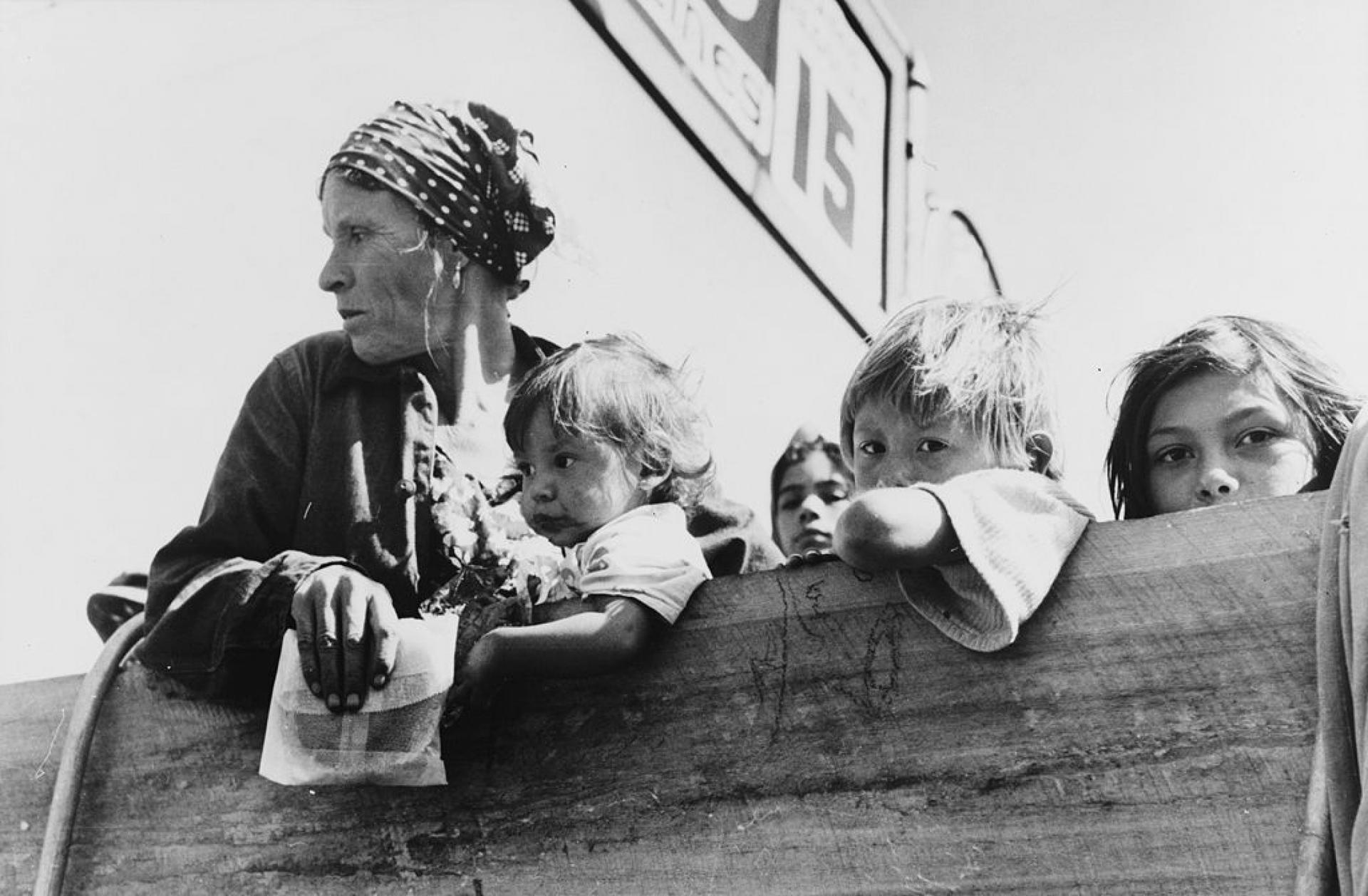 Mexican woman and children looking over side of truck