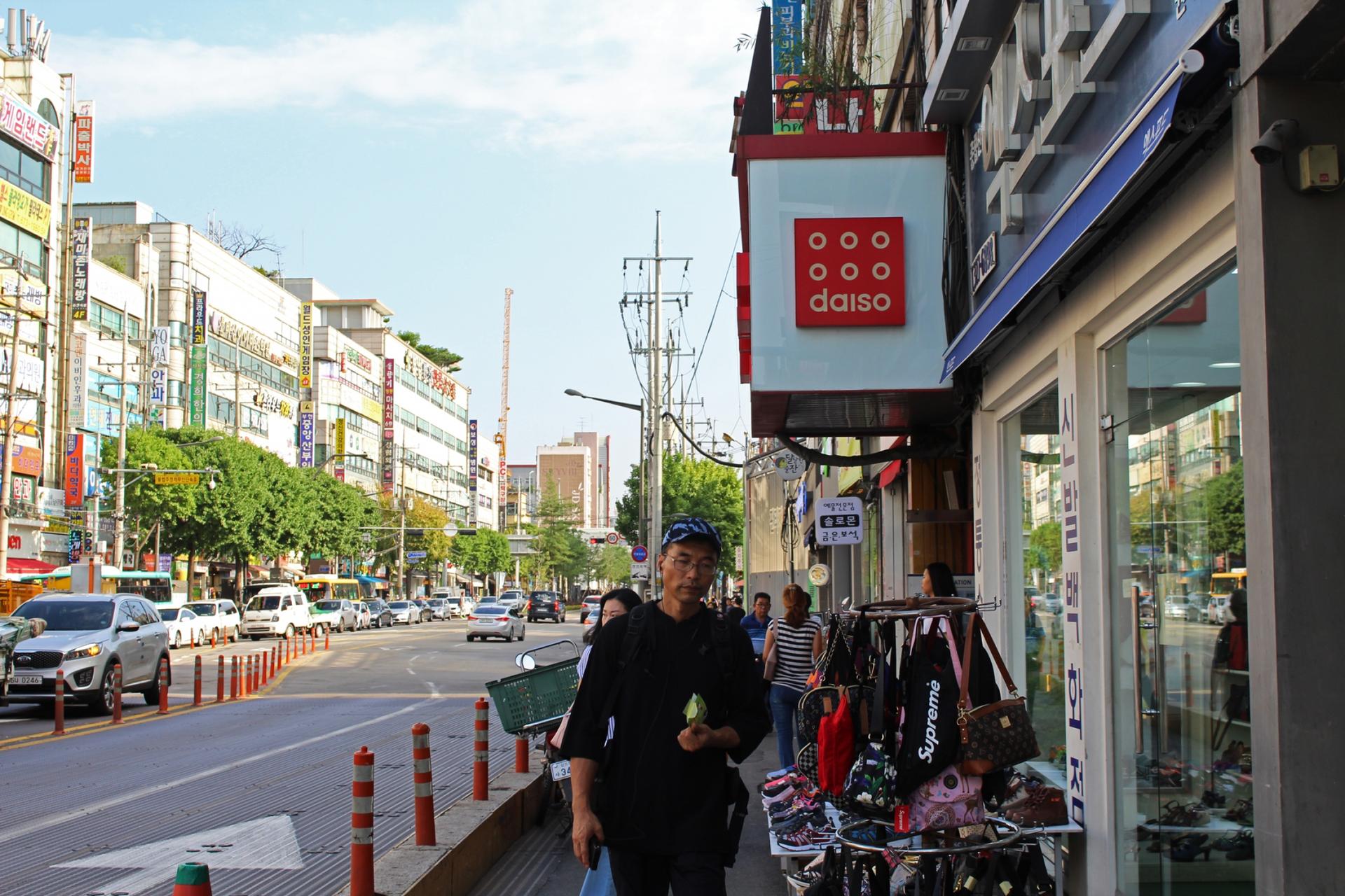 South Koreans walk past the entrance of a Daiso store in Bucheon, a satellite city of Seoul.