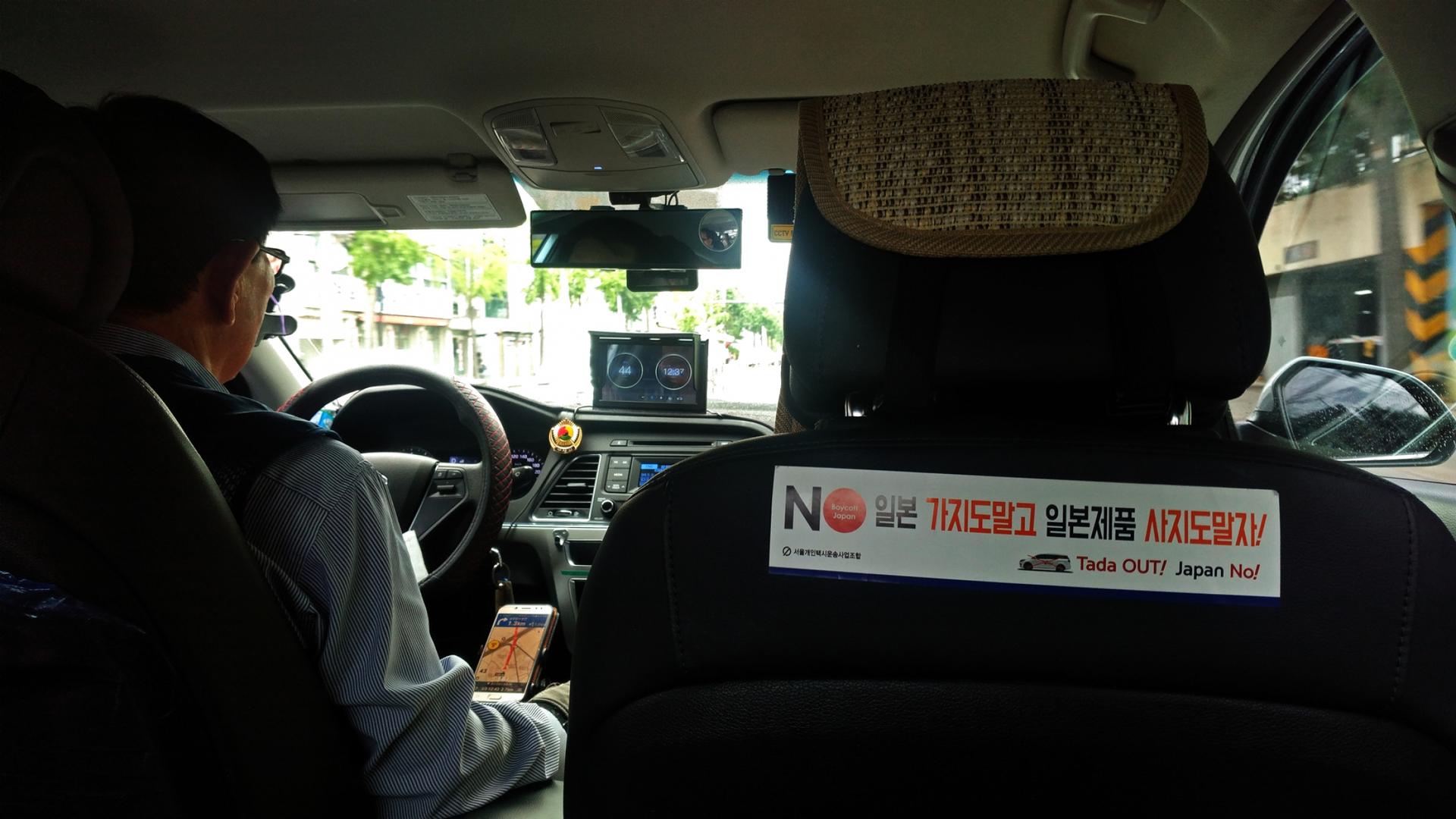 A taxi interior features an anti-Japan sticker