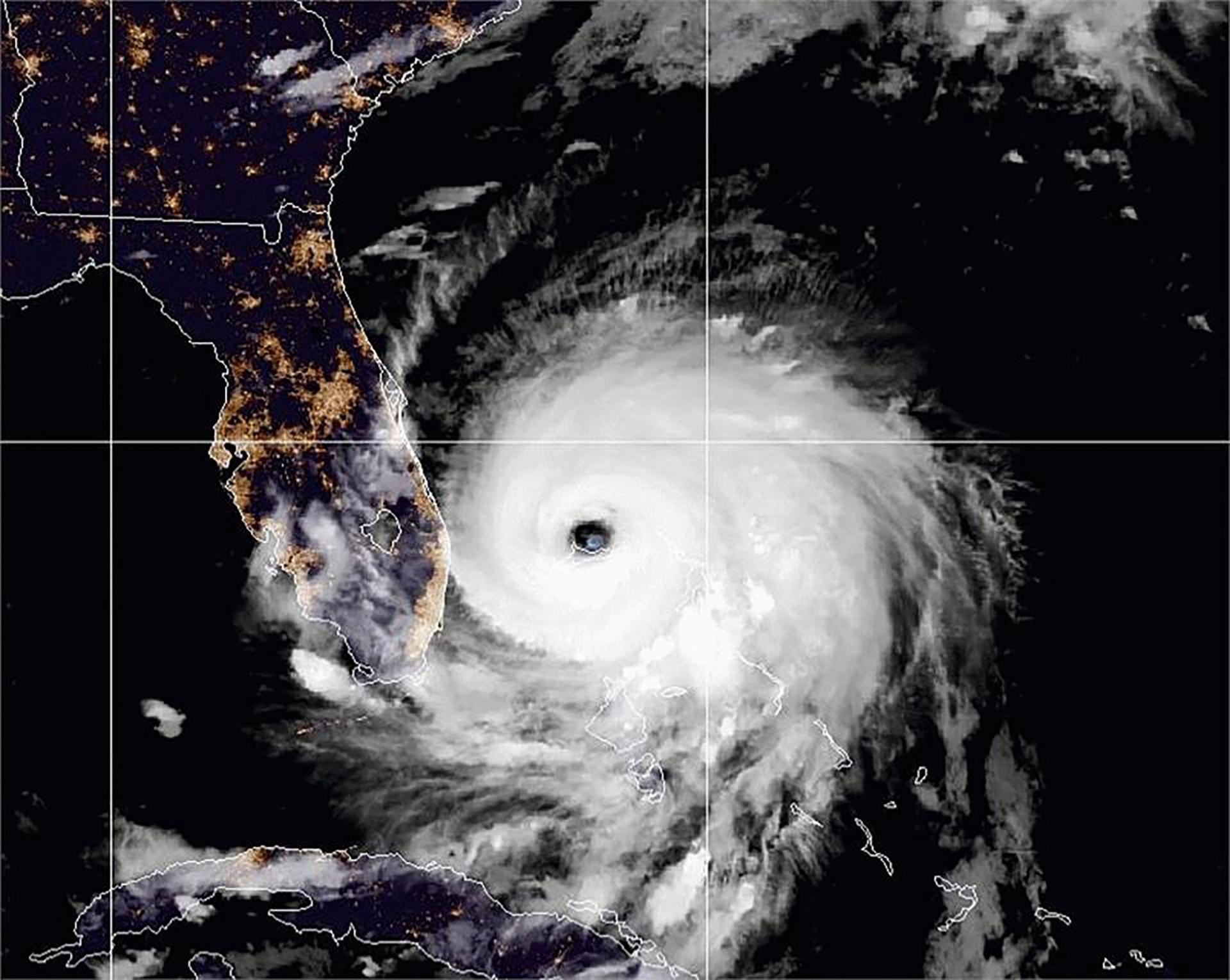 A satellite image shows the outline of Florida with the large spiral of Hurricane Dorian adjacent to the east coast.
