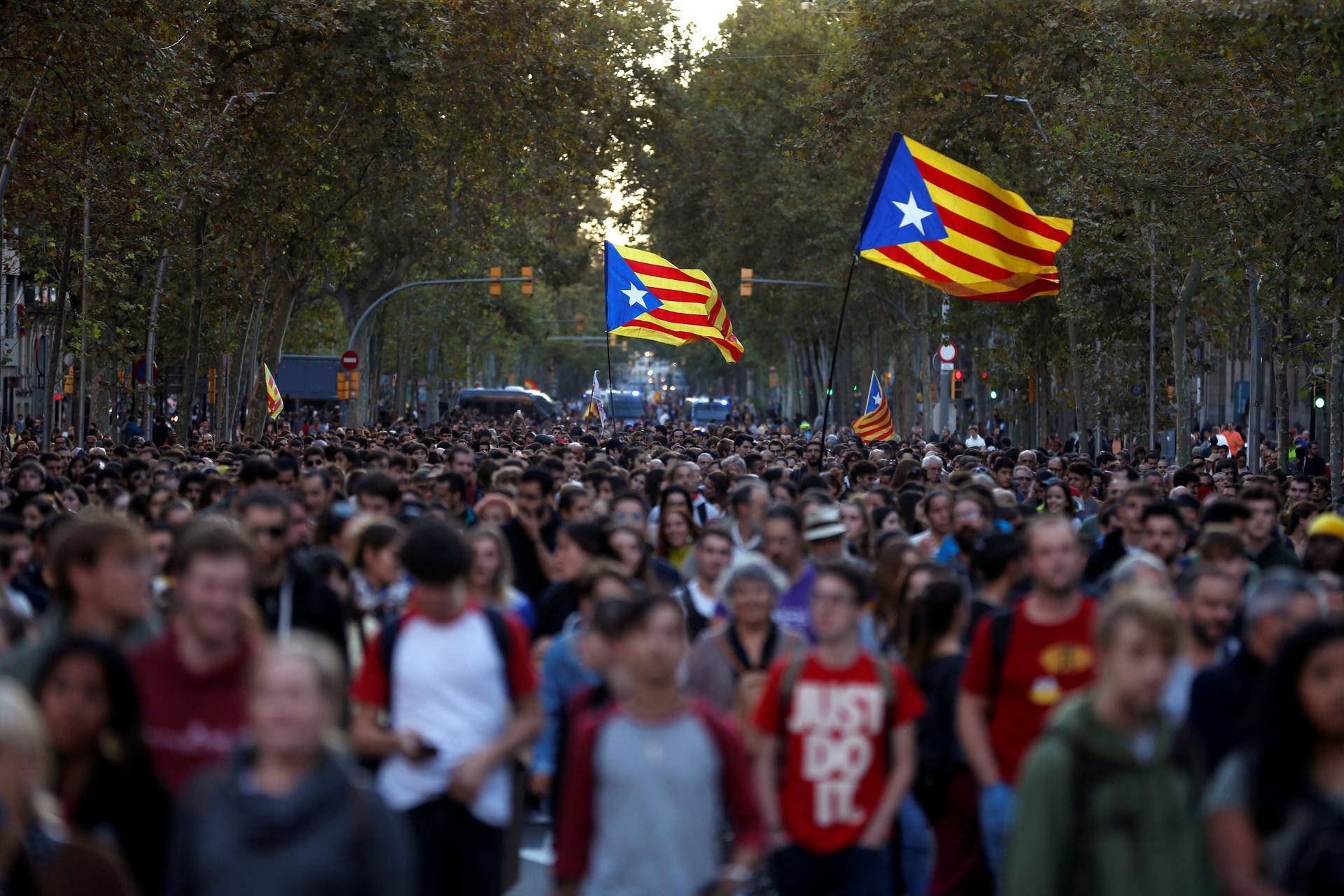 Mass protests in Barcelona with protesters carrying flags 