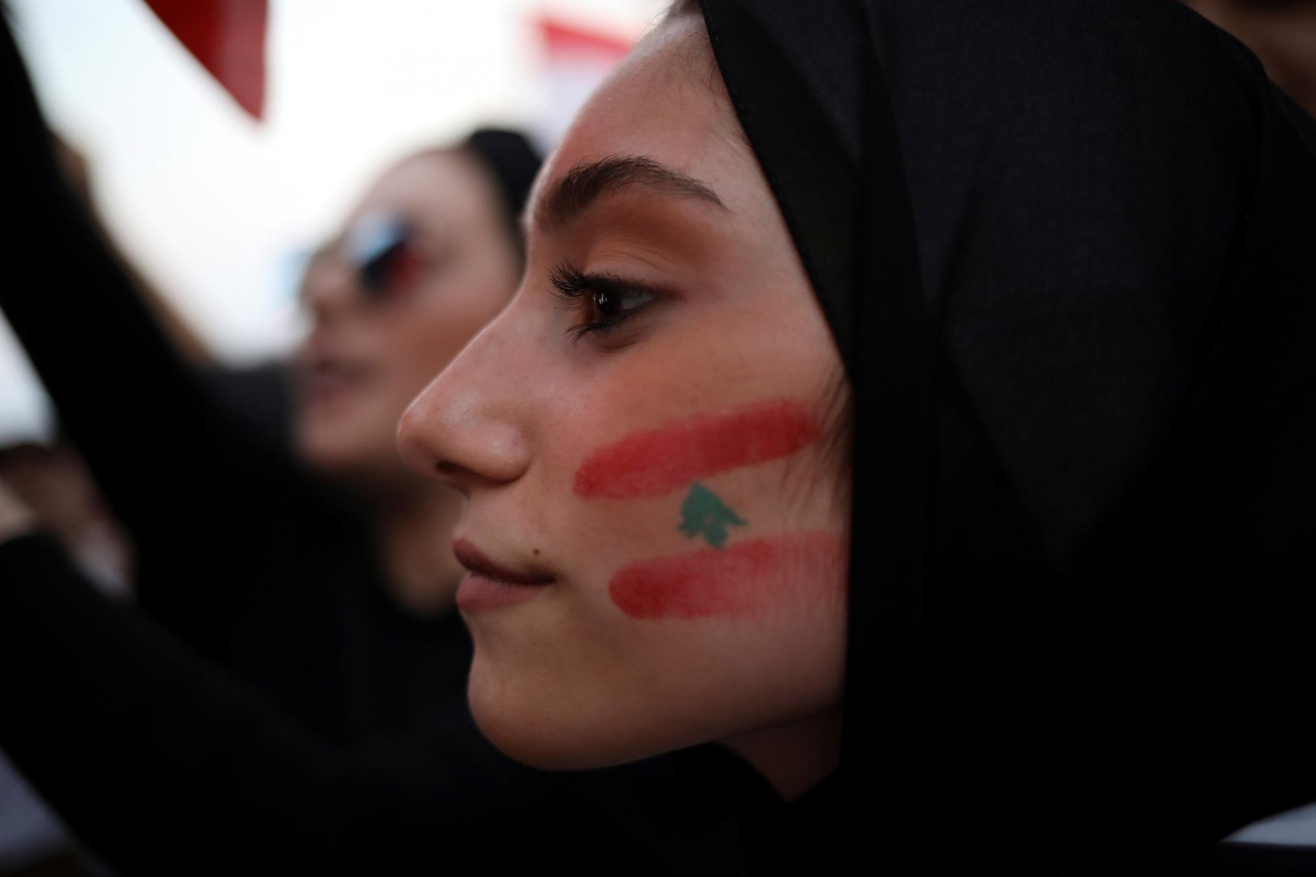 A demonstrator with a Lebanese national flag drawn on her face takes part in an anti-government protest in downtown Beirut, Lebanon, on October 22, 2019