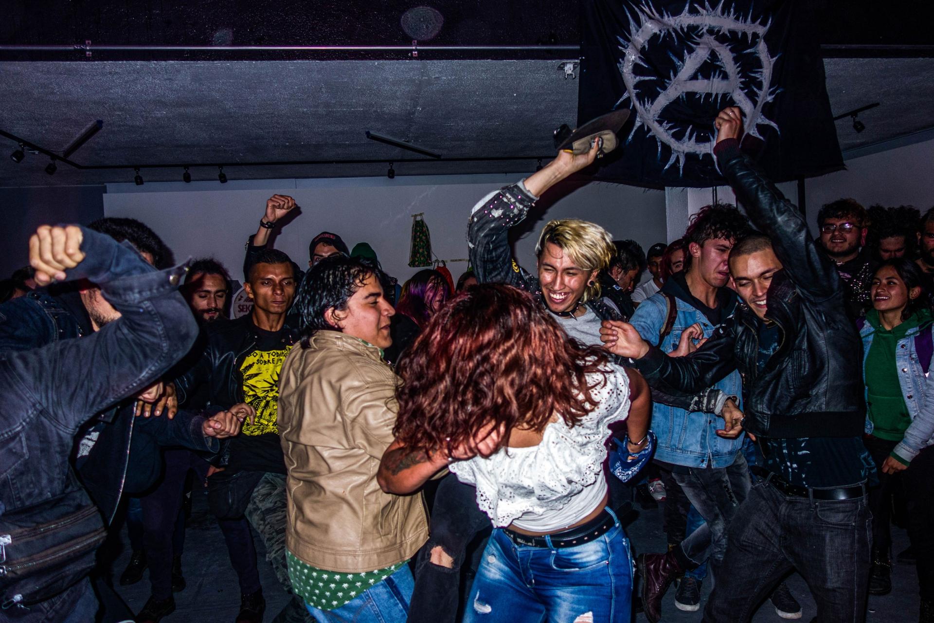 Concert-goers are shown throwing their bodies around at each other at a punk concert.