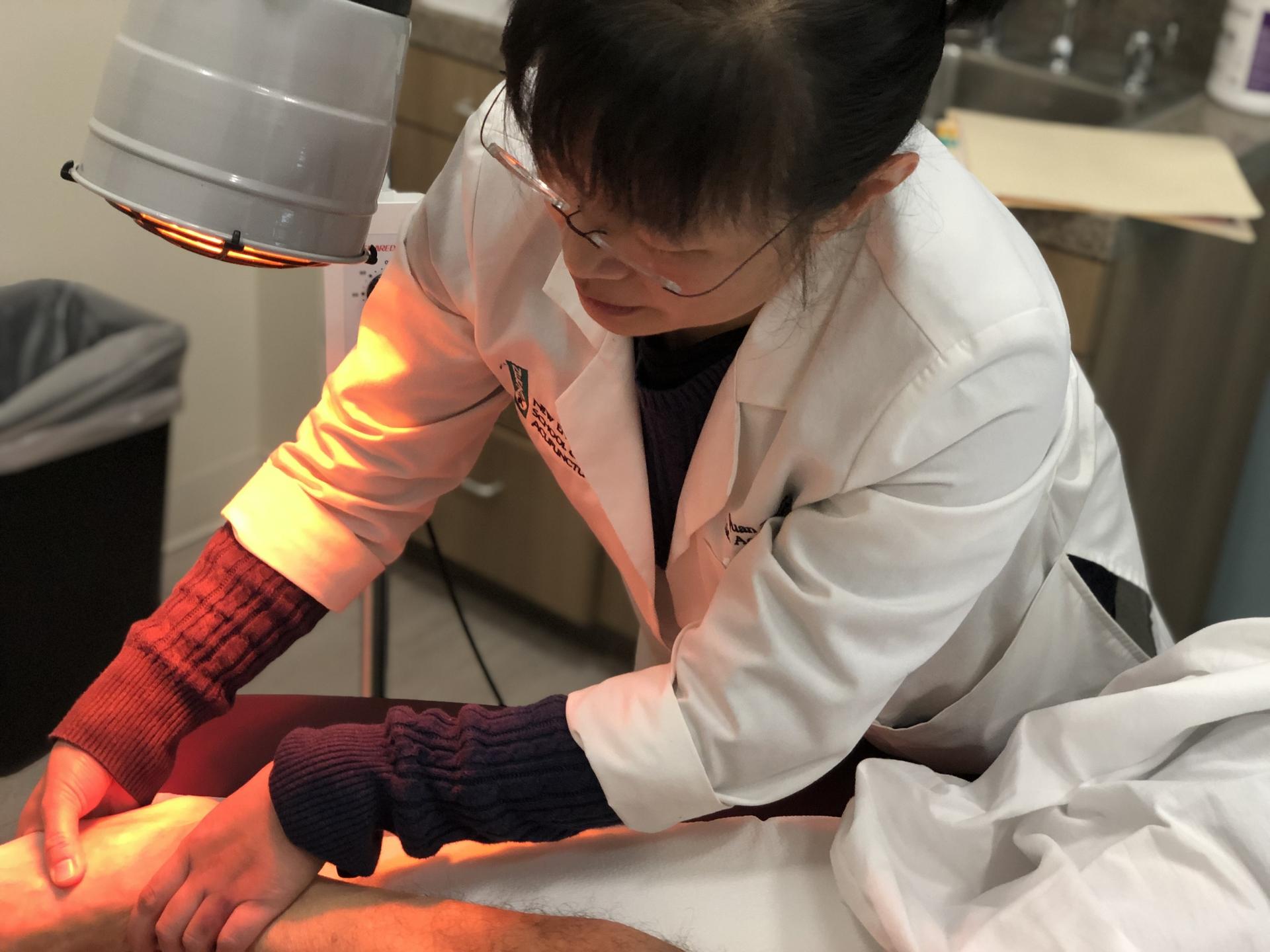 A doctor performs acupuncture on a patient's foot 
