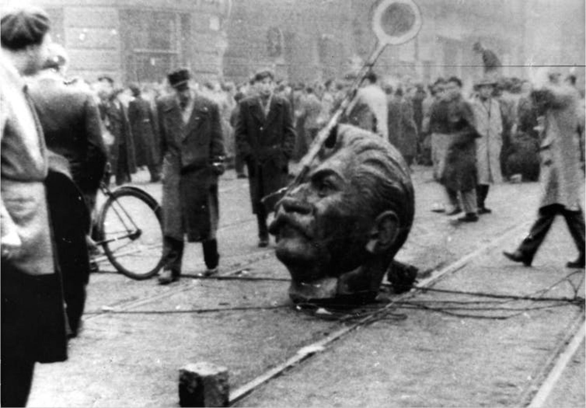 A statue of Stalin's head is on the ground during a revolution in Hungary.
