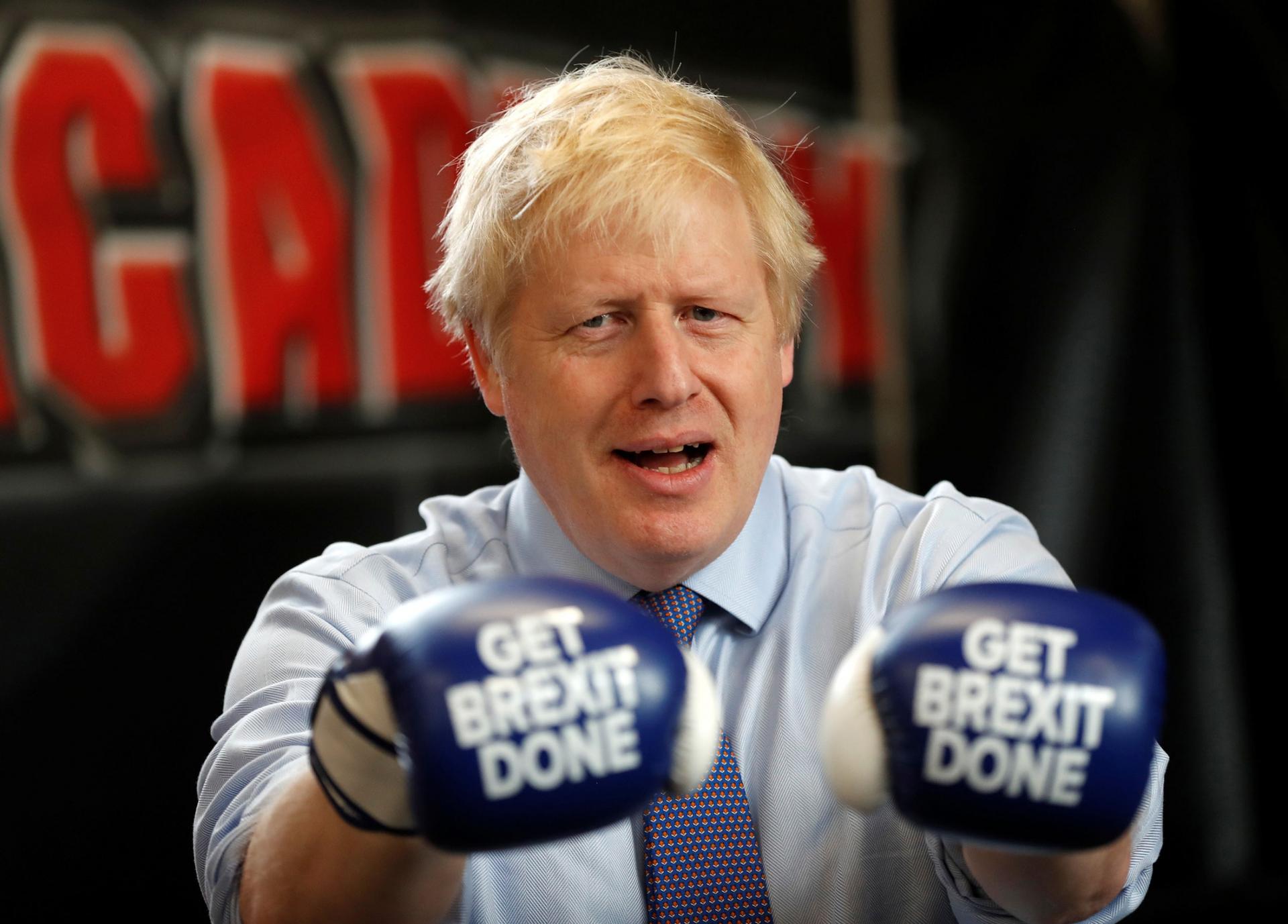 Britain's Prime Minister Boris Johnson is shown wearing blue boxing gloves with the words "Get Brexit Done" printed on them.
