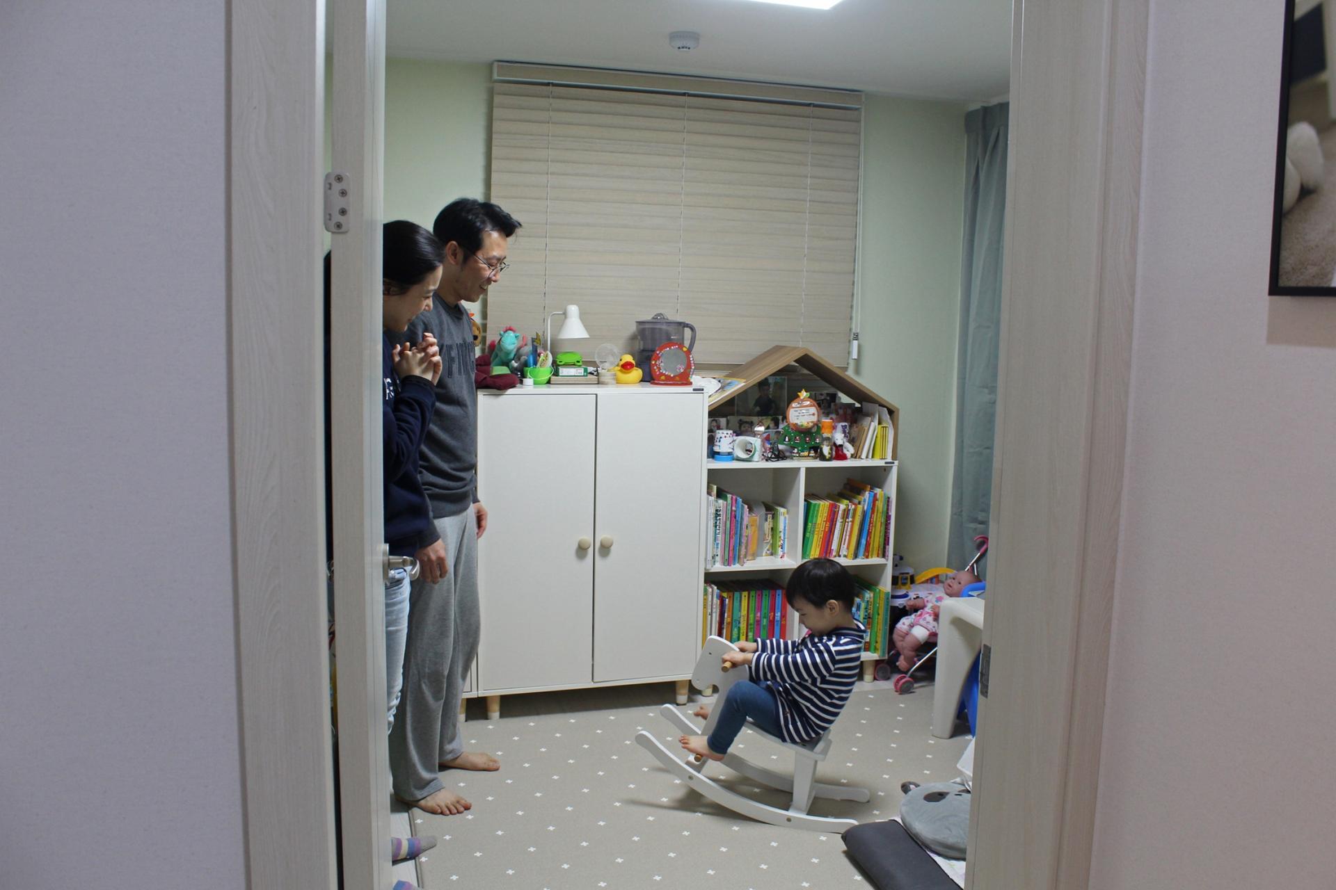 Seo Ji-hye and Cho Sung-won watch as their two-year-old son, Han-sol, rides a rocking horse in his bedroom in Seoul.