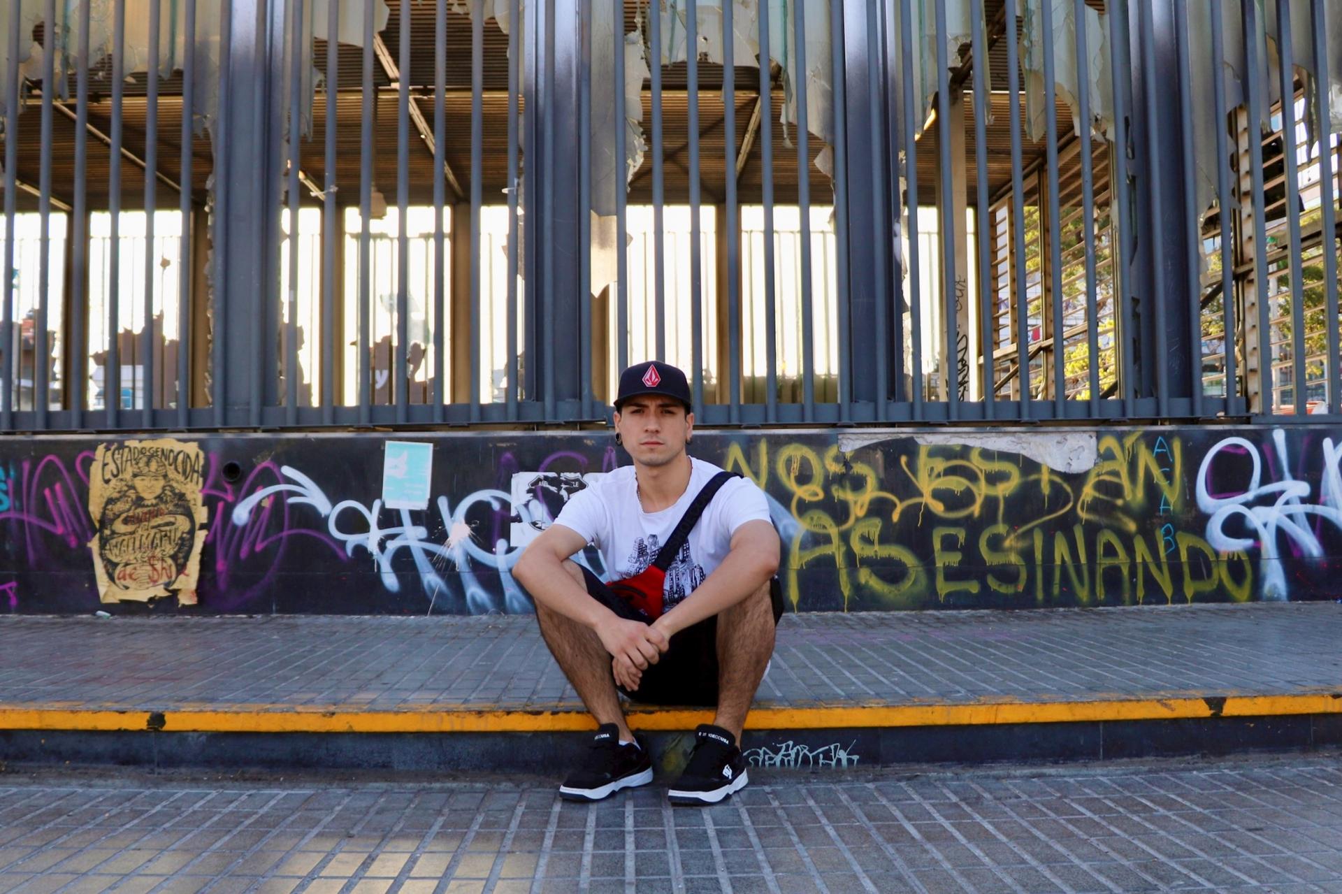 History student Frank Araneda, 23, takes a break from protesting at a vandalized metro station in Maipú, a low-income neighborhood outside of Santiago, Chile. 