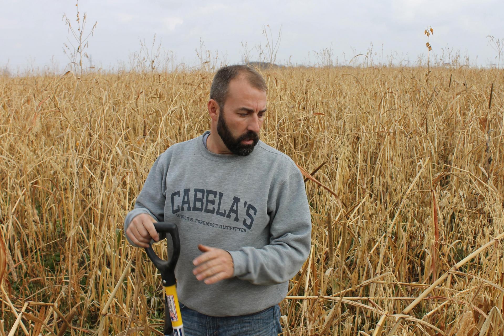 A man is shown wearing a Cabela's sweatshirt and holding a handled-tool.