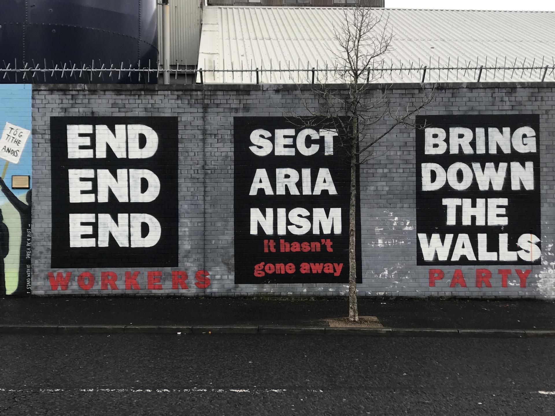 A mural shows messages related to ending sectarianism and taking down walls in Belfast, Northern Ireland. 