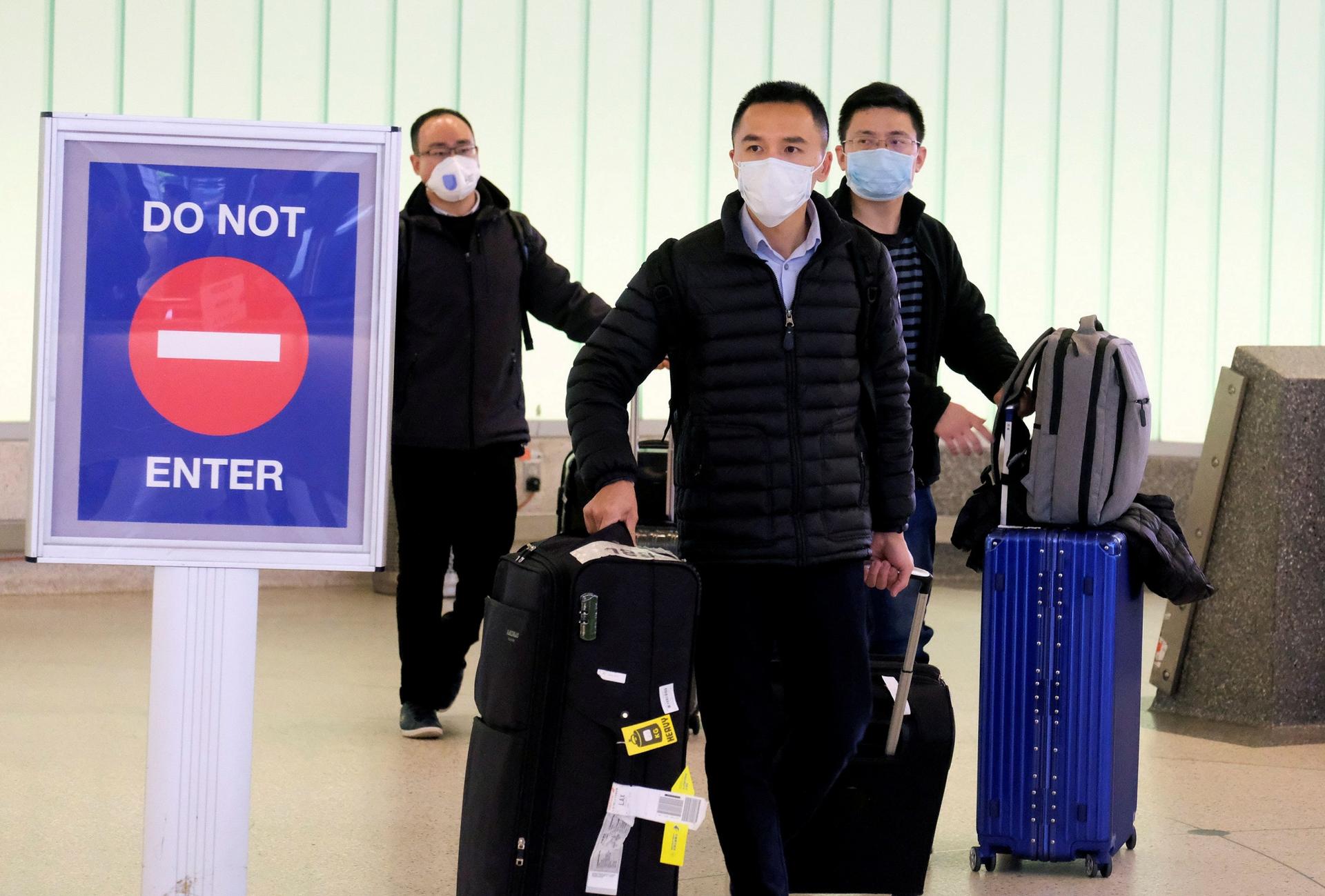 Passengers arrive at LAX from Shanghai, China, after a positive case of the coronavirus was announced in the Orange County suburb of Los Angeles, Jan. 26, 2020. 