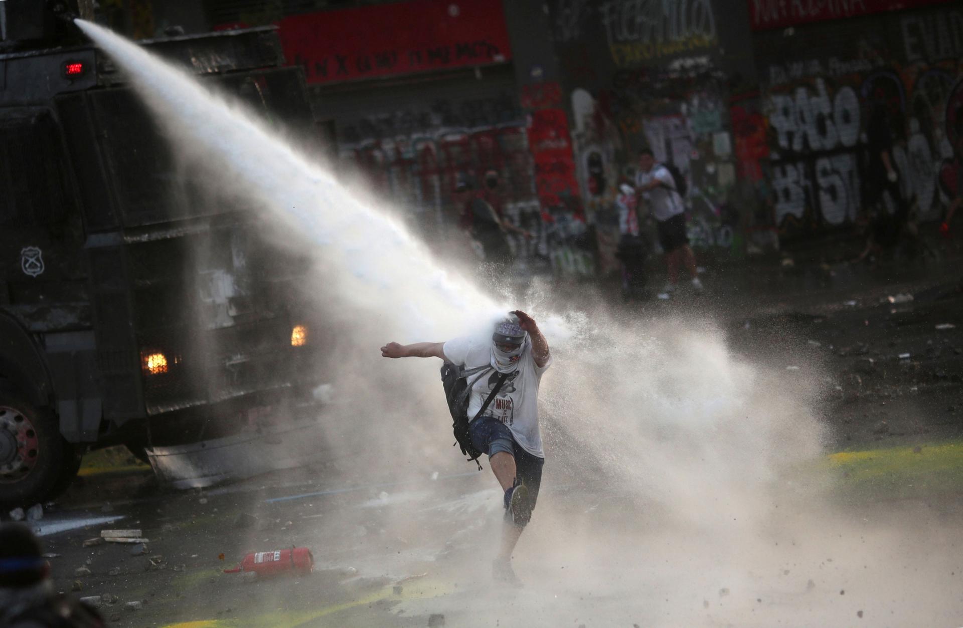 A person is shown being sprayed by a water cannon from above.