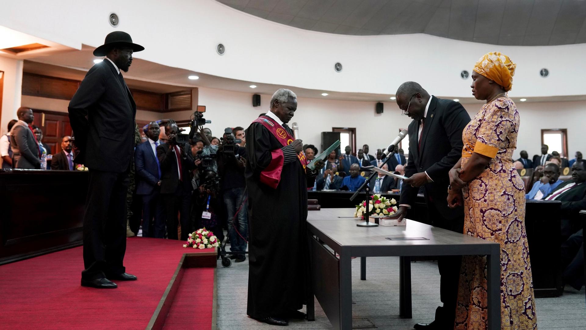 South Sudan's First Vice President Riek Machar takes the oath of office in front of President Salva Kiir and Chief Justice Chan Reech Madut at the State House in Juba, South Sudan, Feb. 22, 2020. 