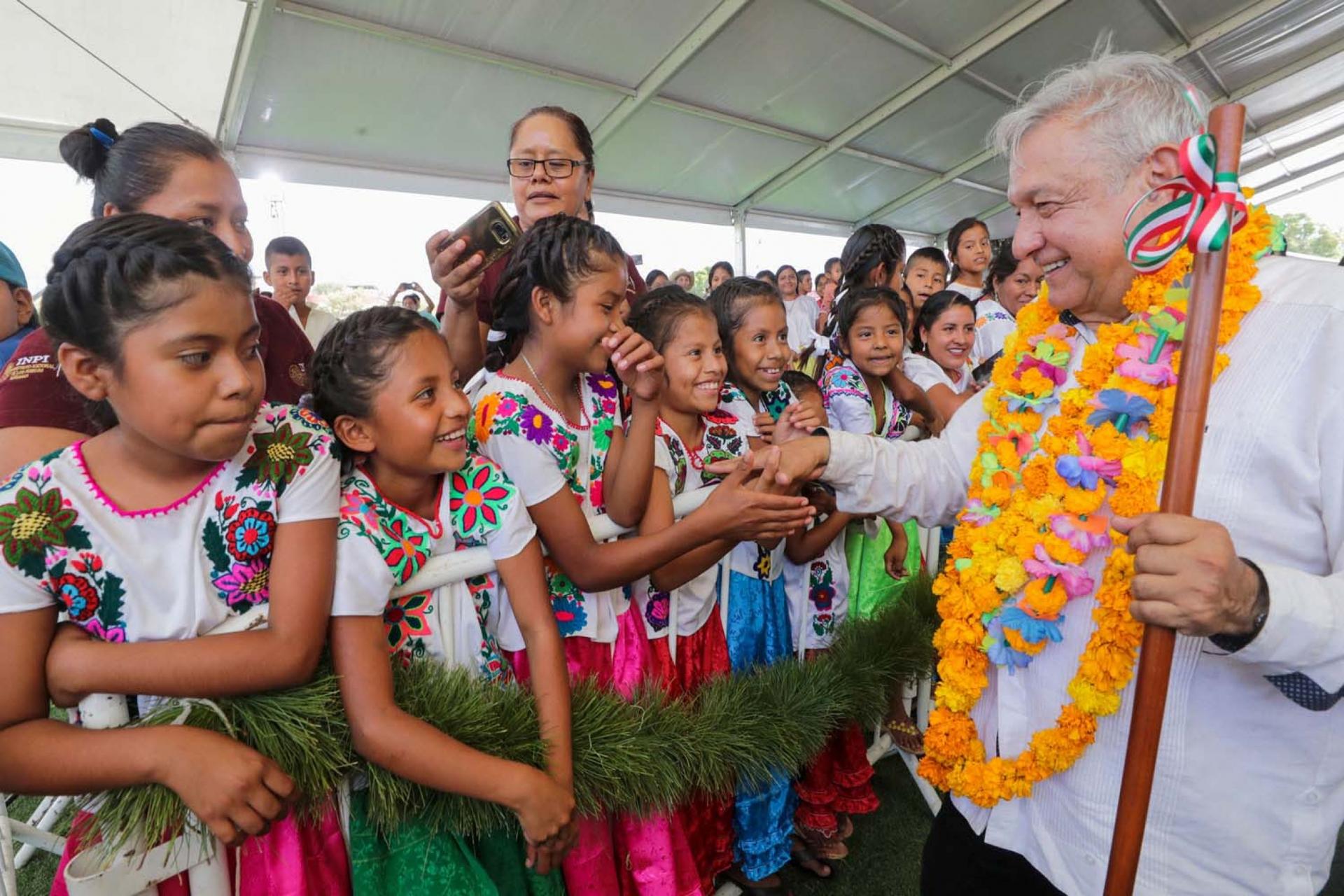 Mexico's President Andres Manuel Lopez Obrador shakes hands with girls while visiting towns in the southwestern state of Guerrero, as Mexico's health ministry urged people to mantain a "healthy distance" to avoid infection and spread of coronavirus.