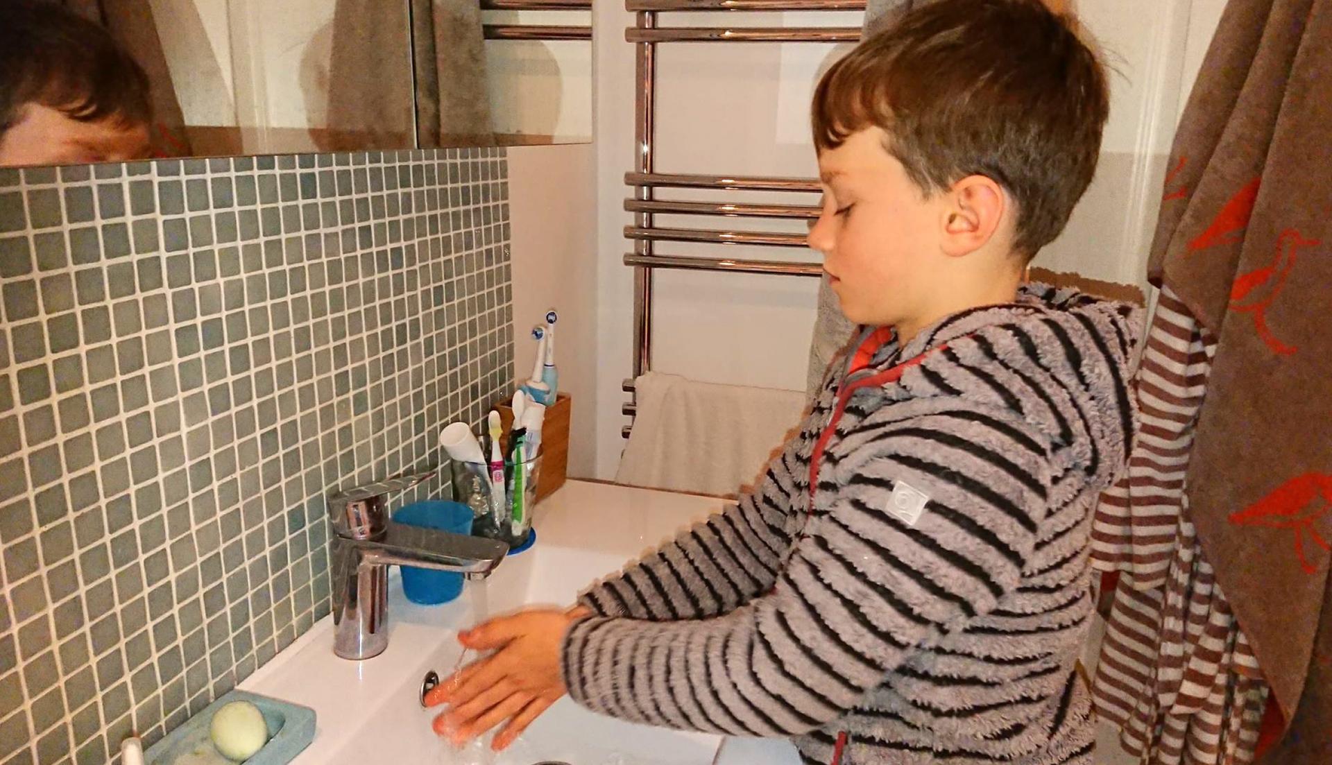Jacob Gortmans demonstrates the proper 20-second hand-washing duration at his home in London.