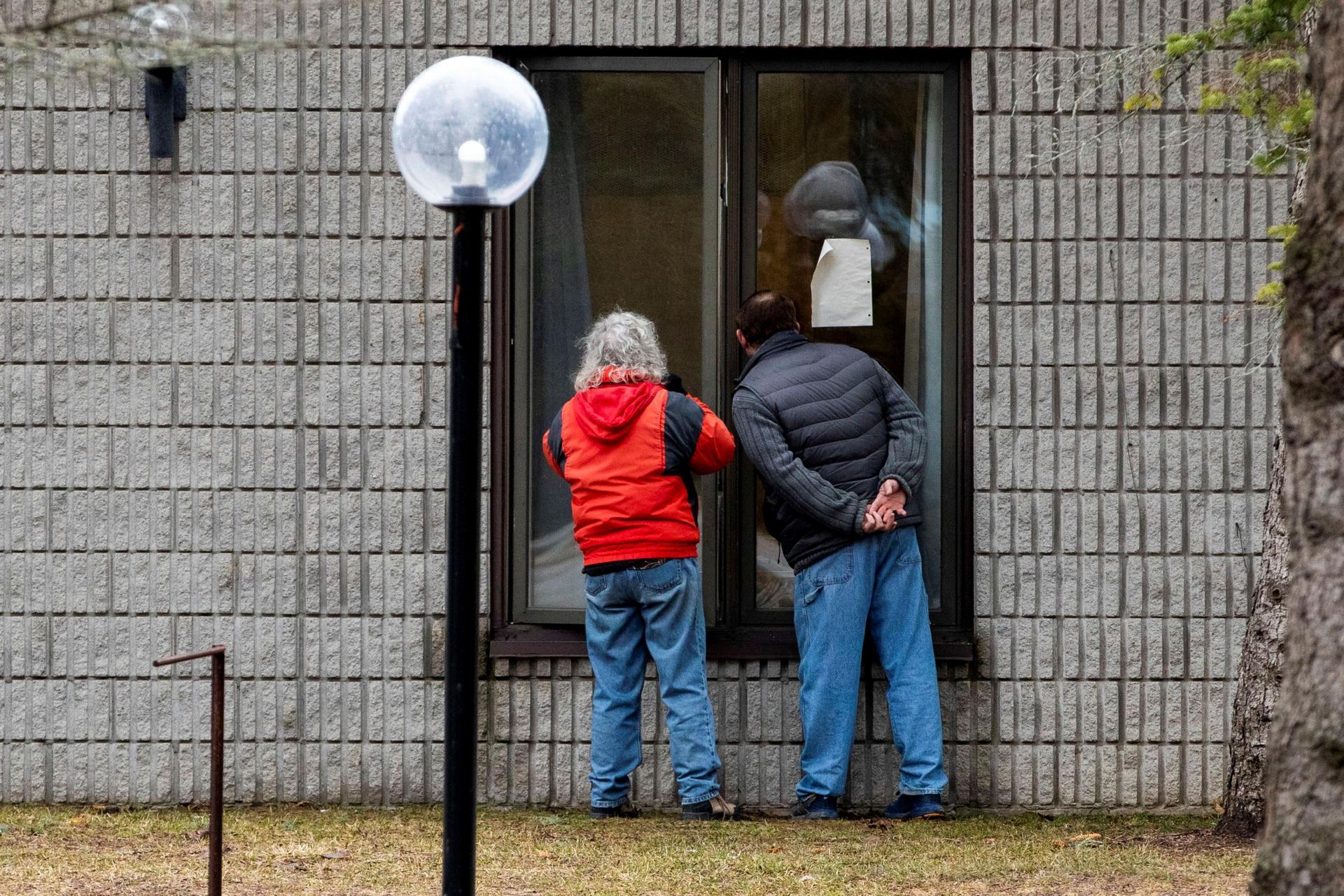 Two people speak to a resident through a window at Pinecrest Nursing Home after several residents died and dozens of staff were sickened by coronavirus disease (COVID-19) in Bobcaygeon, Ontario, Canada, on March 30, 2020.