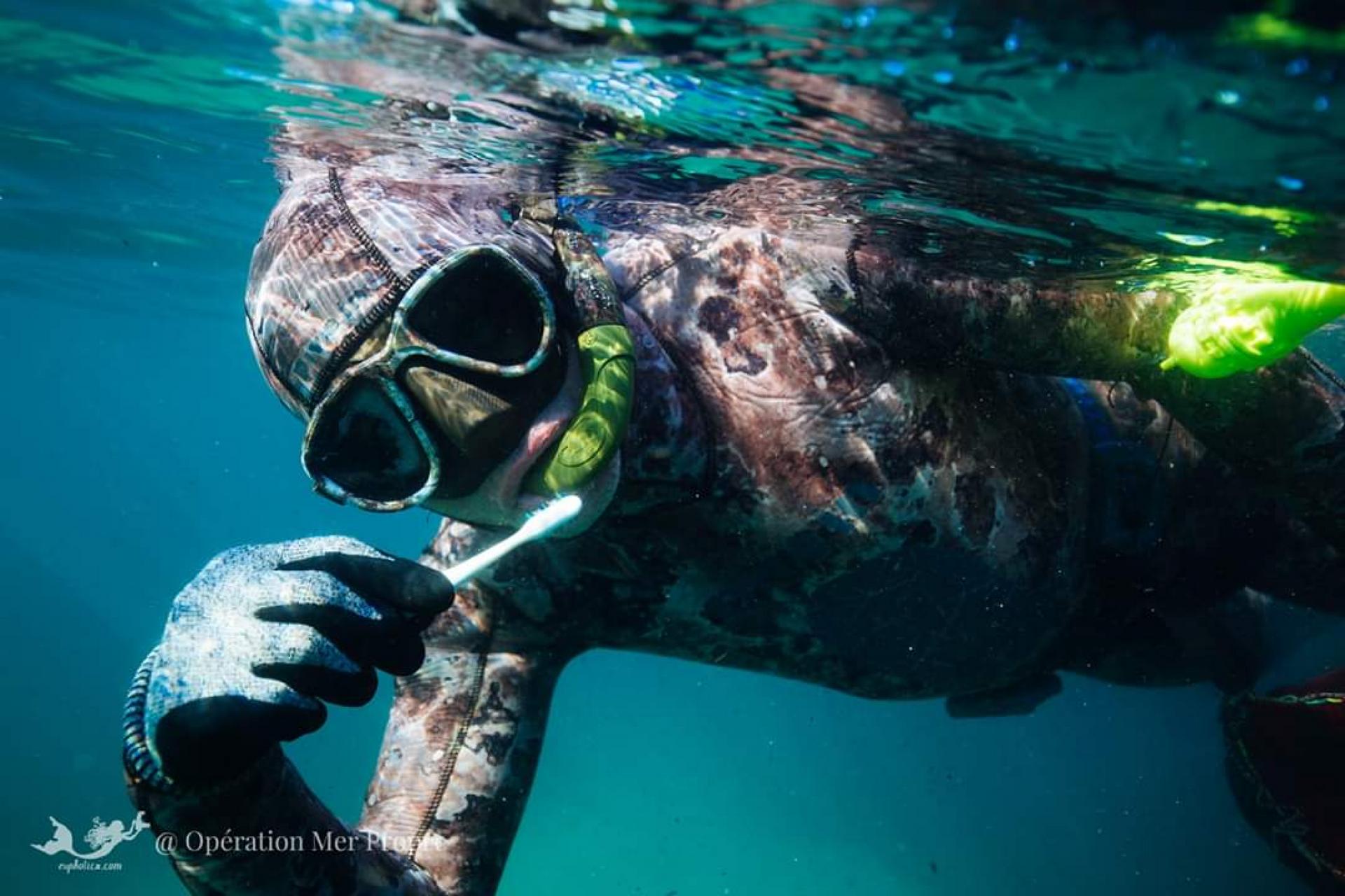 Joko Peltier, cofounder of France's Operation Clean Sea, shows a toothbrush he found underwater while clearing litter.