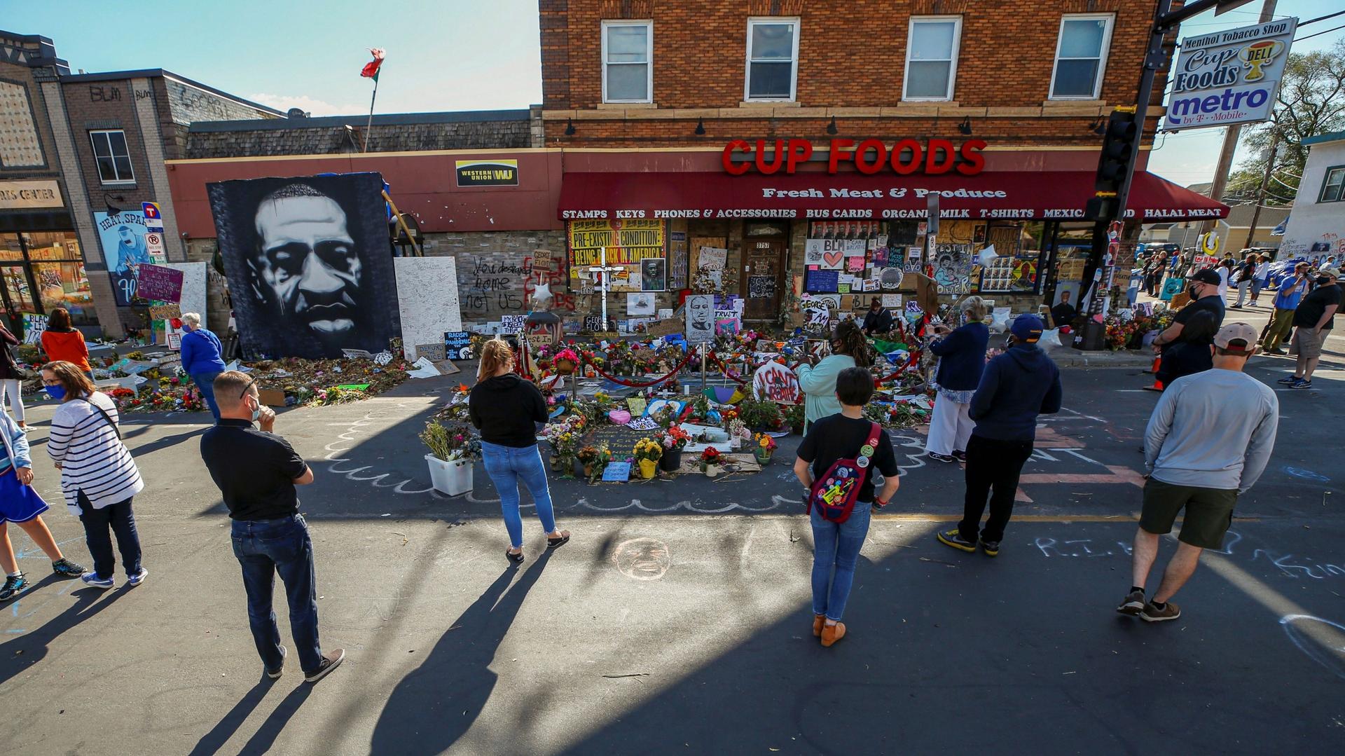 Visitors look at a memorial at the site of the arrest of George Floyd, who died while in police custody, in Minneapolis, June 14, 2020. 