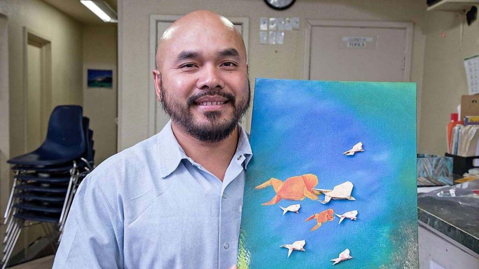 Chanthon Bun, who was incarcerated for 23 years, part of that time in San Quentin State Prison in California, shows artwork from an origami course offered in the prison.