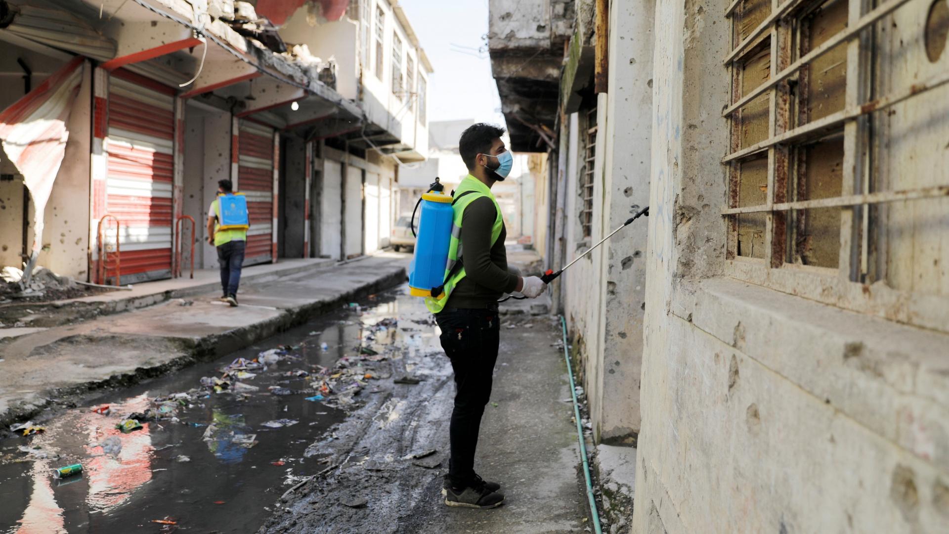 Iraqi young volunteers spray with disinfectants to combat an outbreak of coronavirus during a curfew imposed by Iraqi authorities, in the old city of Mosul, Iraq, March 15, 2020. 