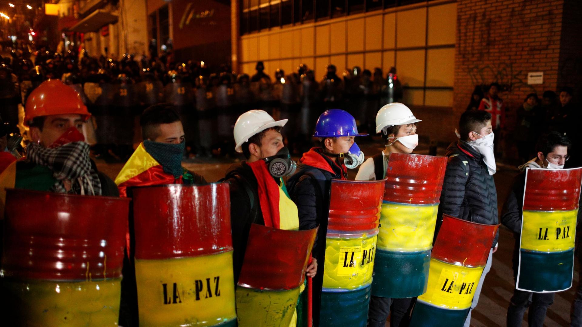 Demonstrators with makeshift shields protest against President Evo Morales' reelection, in La Paz, Boliva, Nov. 6, 2019.