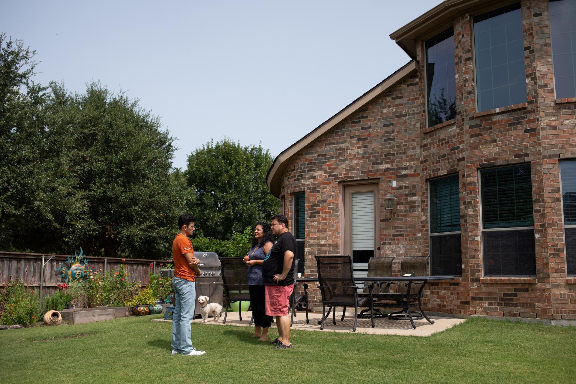 Izcan Ordaz, left, and his parents in the backyard of their home in Fort Worth, Texas.