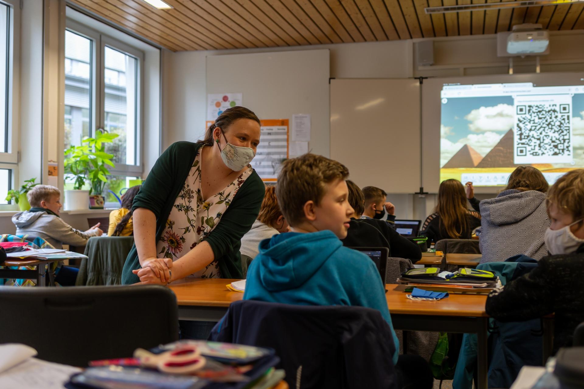Teacher Inga Deppa works with students in an English class at Jacobishule in Kalletal, Germany. Masks were optional for students when they were seated at their desks but the regional health authority has since tighten mask rules for older students.