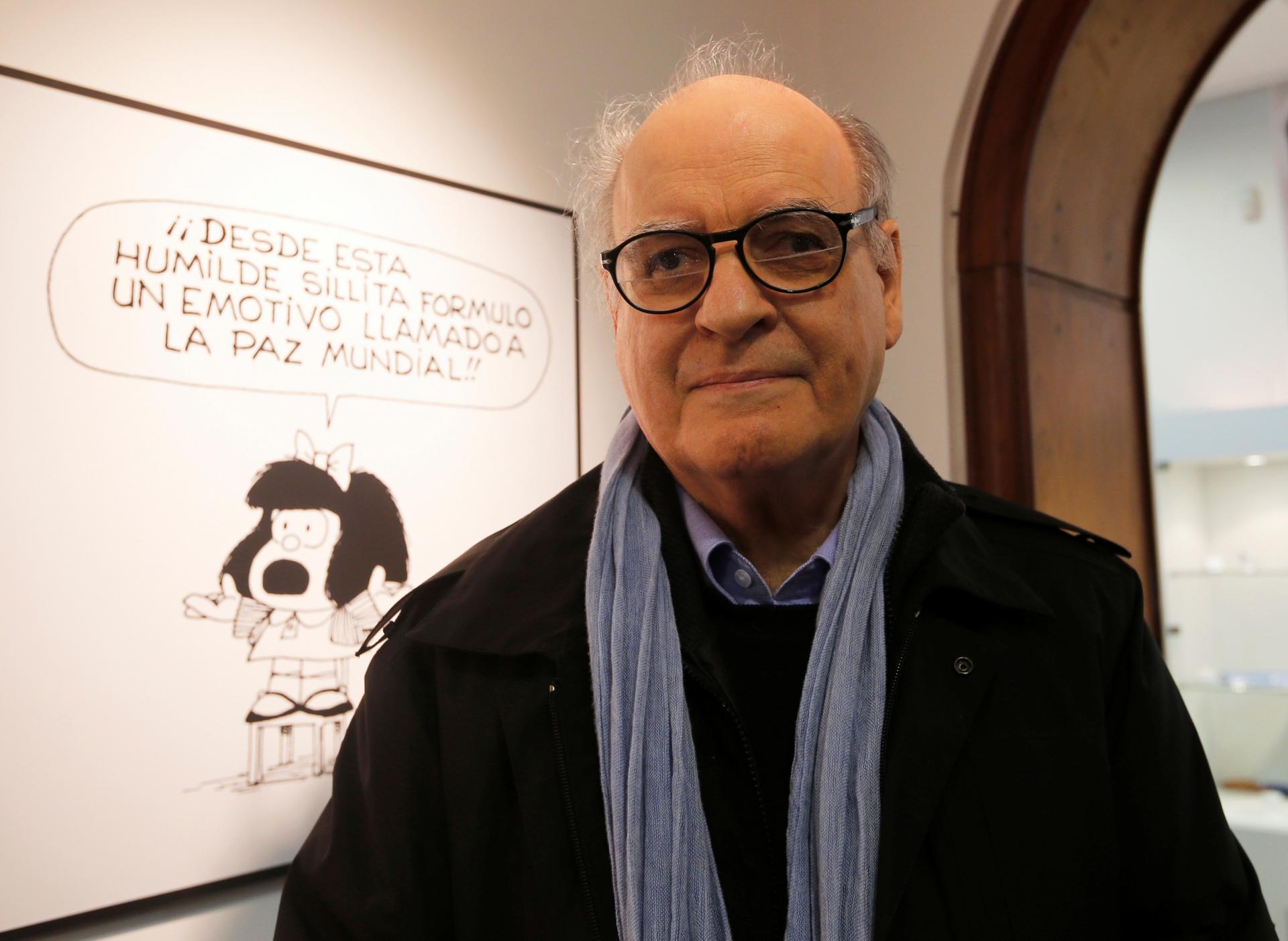 Argentine cartoonist Joaquín Salvador Lavado, also known by his pen name Quino, poses in front of an image of his most famous comic character Mafalda during the opening ceremony of the exhibition of his works at the Museo del Humor in Buenos Aires, June 1
