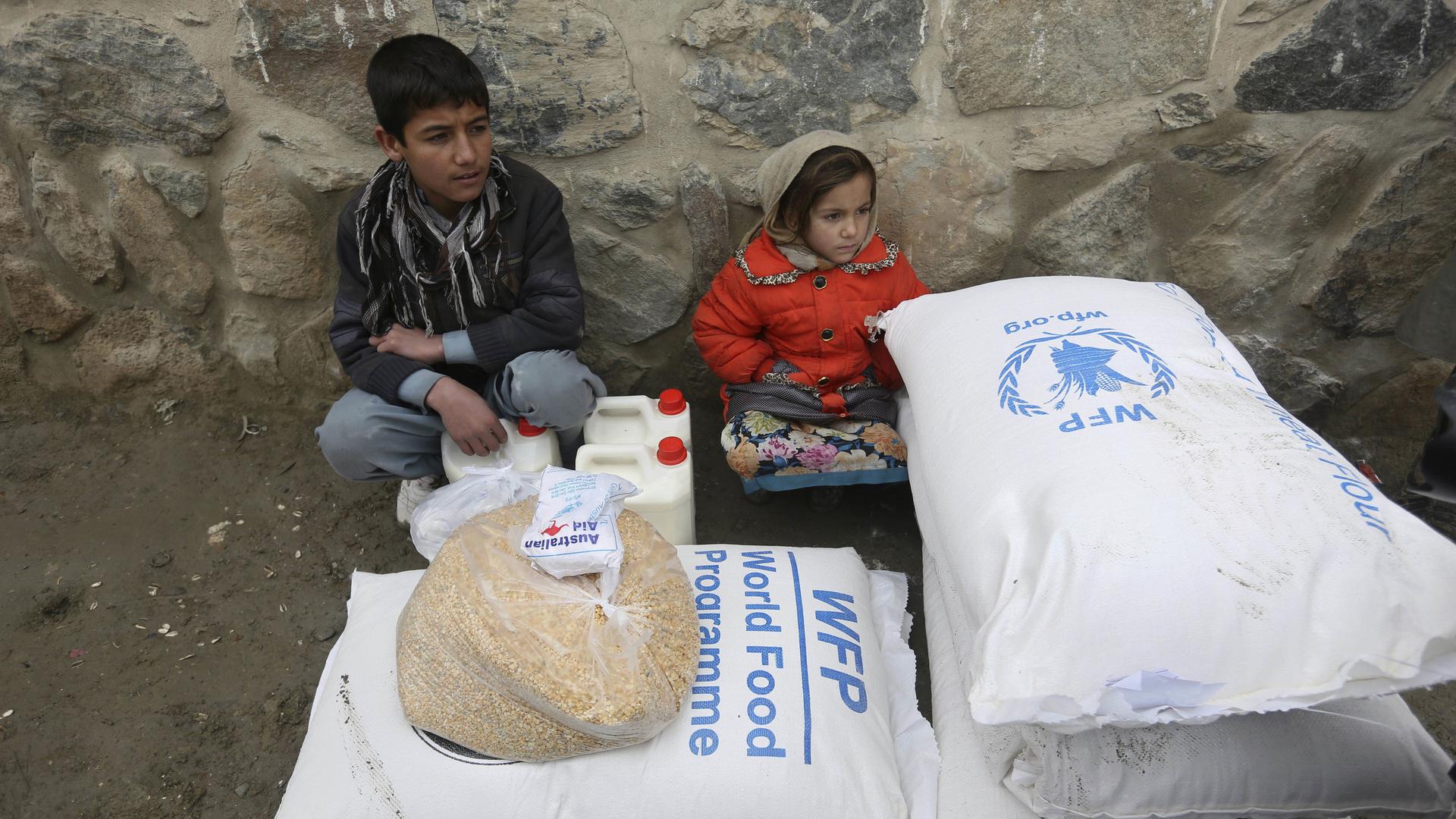 In this Jan. 24, 2017 file photo, children wait for transportation after receiving food donated by the World Food Program, in Kabul, Afghanistan. 