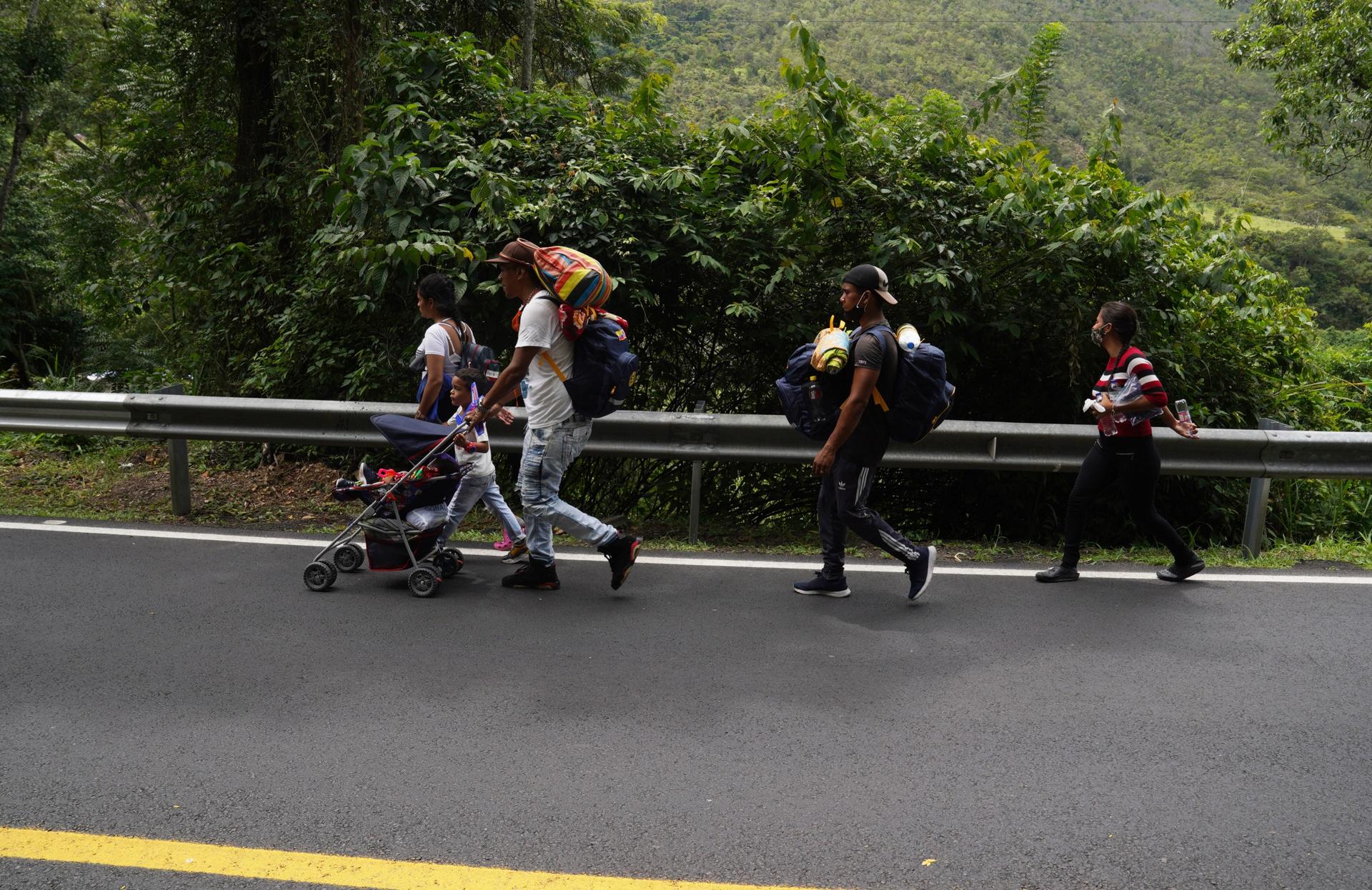 A family from Caracas, Venezuela walks along the road leading to Pamplona, Colombia, on Sept. 30. This family was heading to Ecuador where they had been promised work on a farm. 