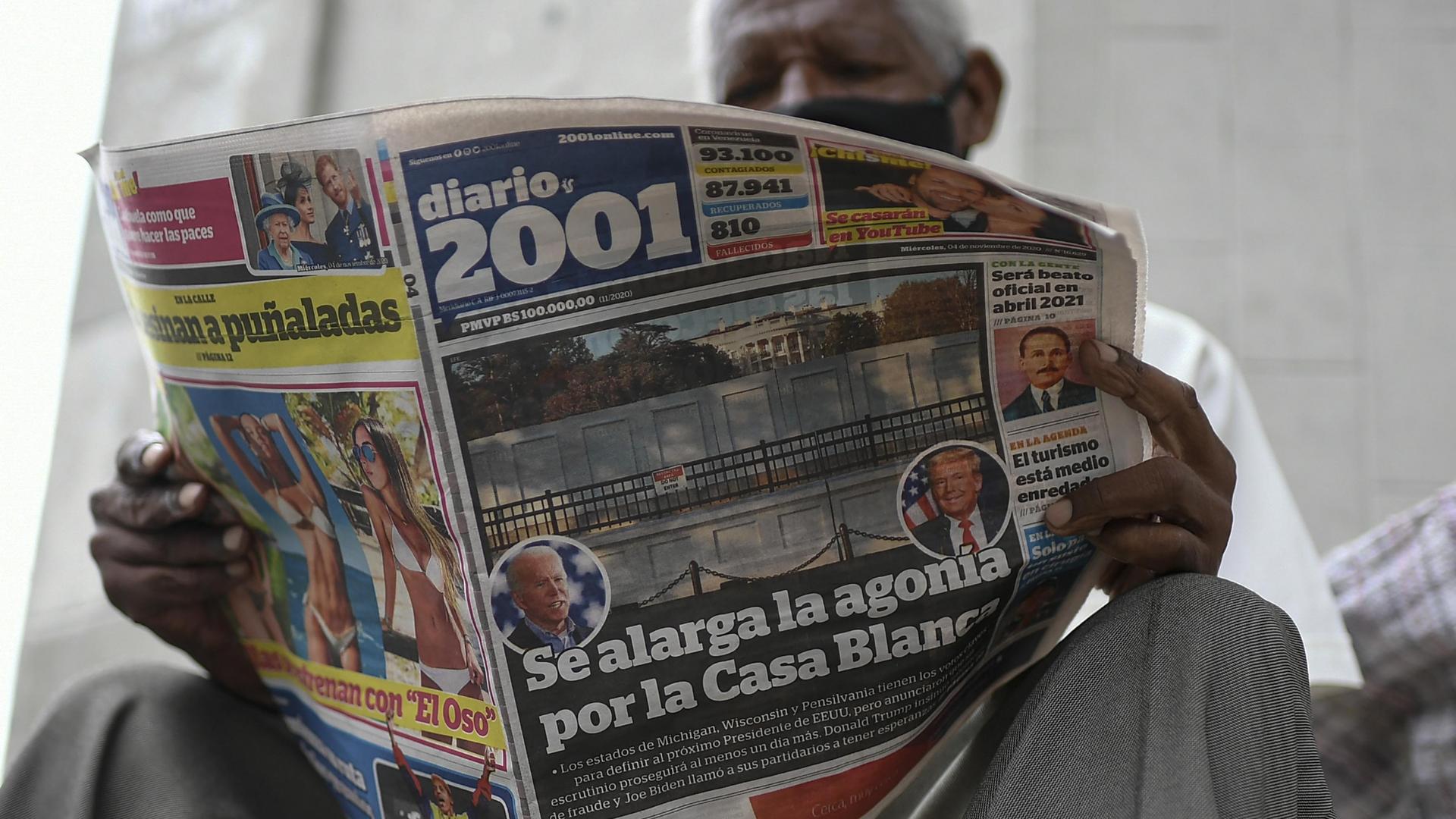 A man reads the Diario 2001 newspaper that carries the Spanish headline: "Agony is prolonged for the White House" at a newspaper stand in Caracas, Venezuela, Nov. 4, 2020, the day after US elections.