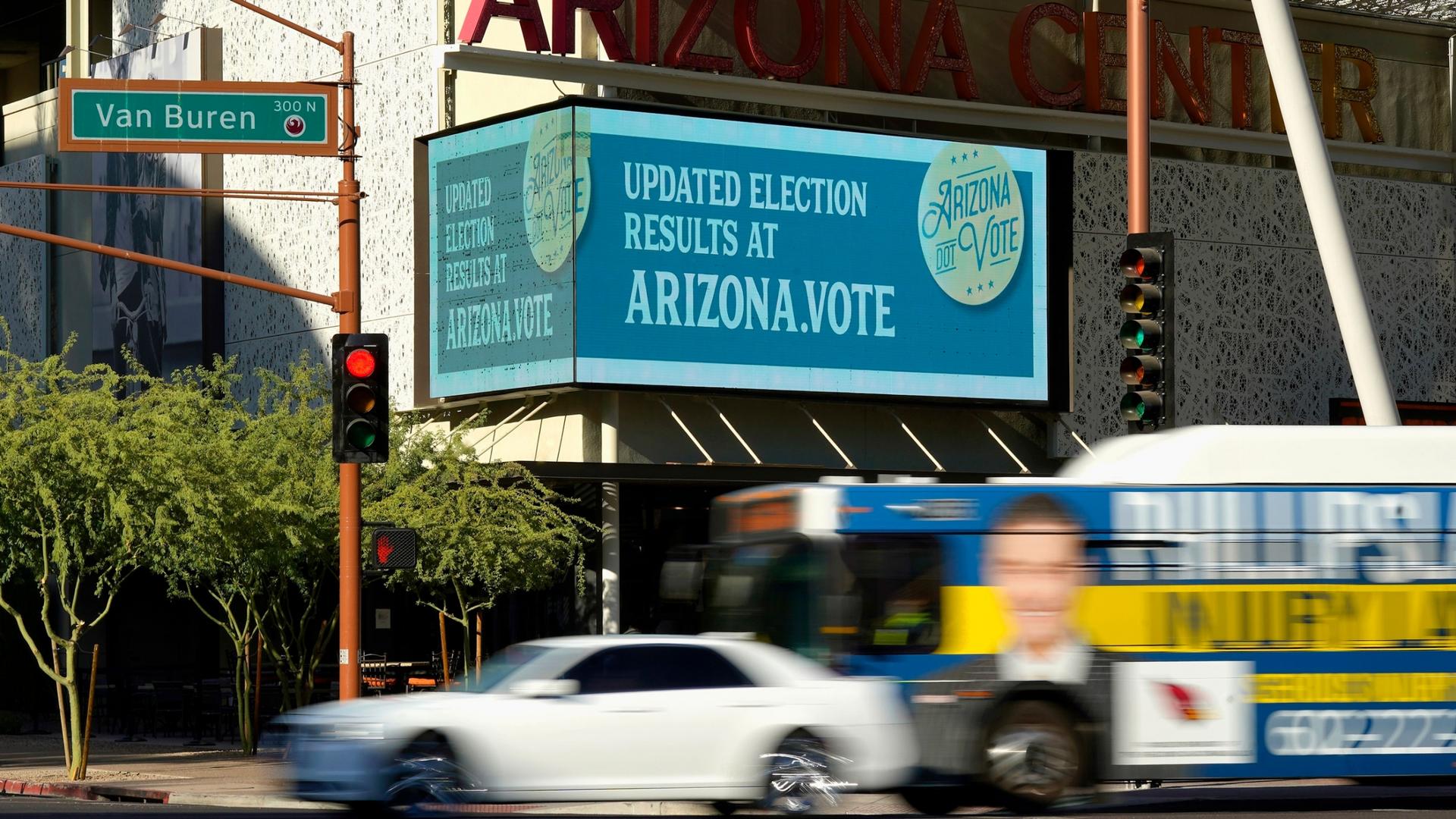 An electonic billboard is shown with information about the Arizona vote as vehicles pass by.