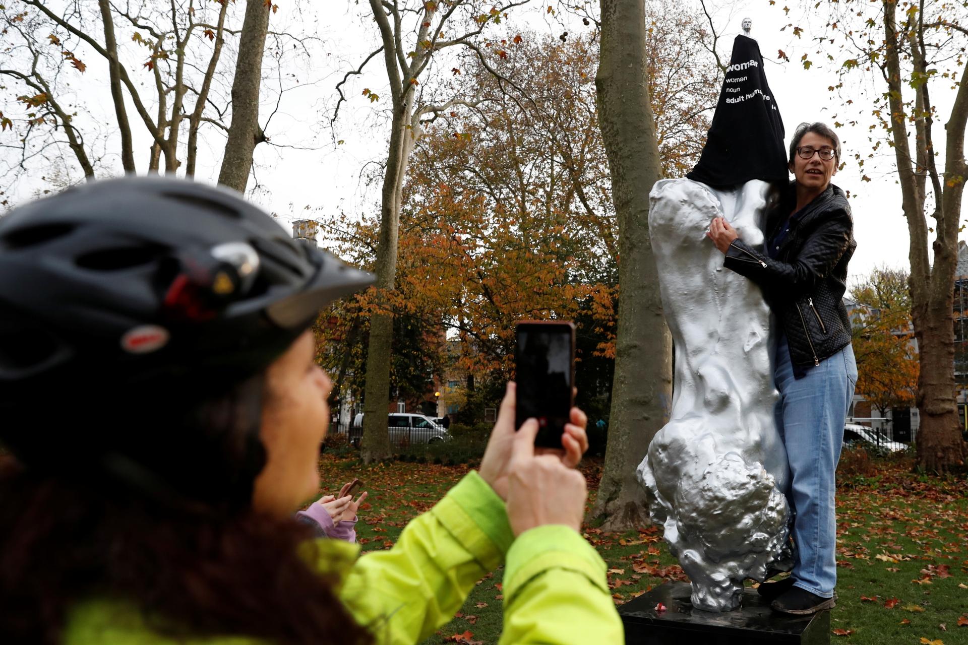 A protester covers with a T-shirt the Mary Wollstonecraft statue by artist Maggi Hambling, in Newington Green, London, Britain, Nov. 11, 2020. 