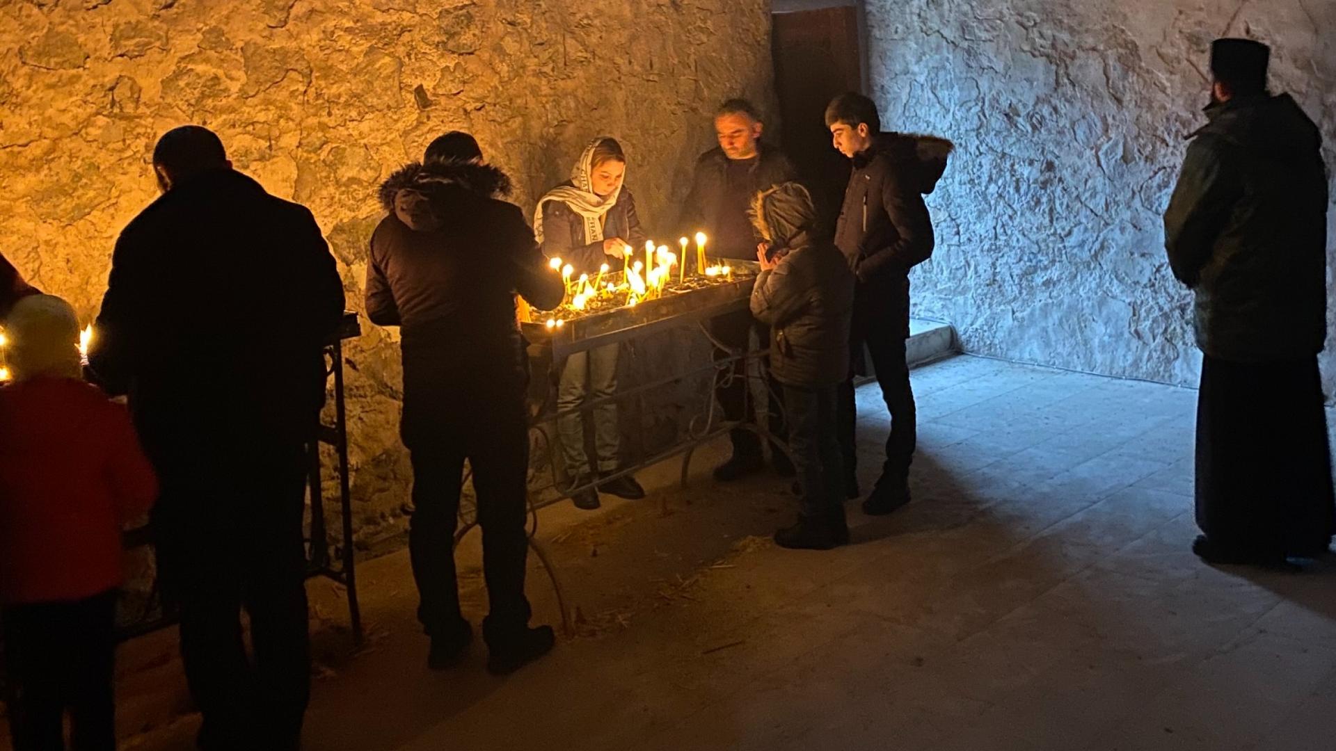 Armenian worshippers light candles inside the Dadivank Monastery