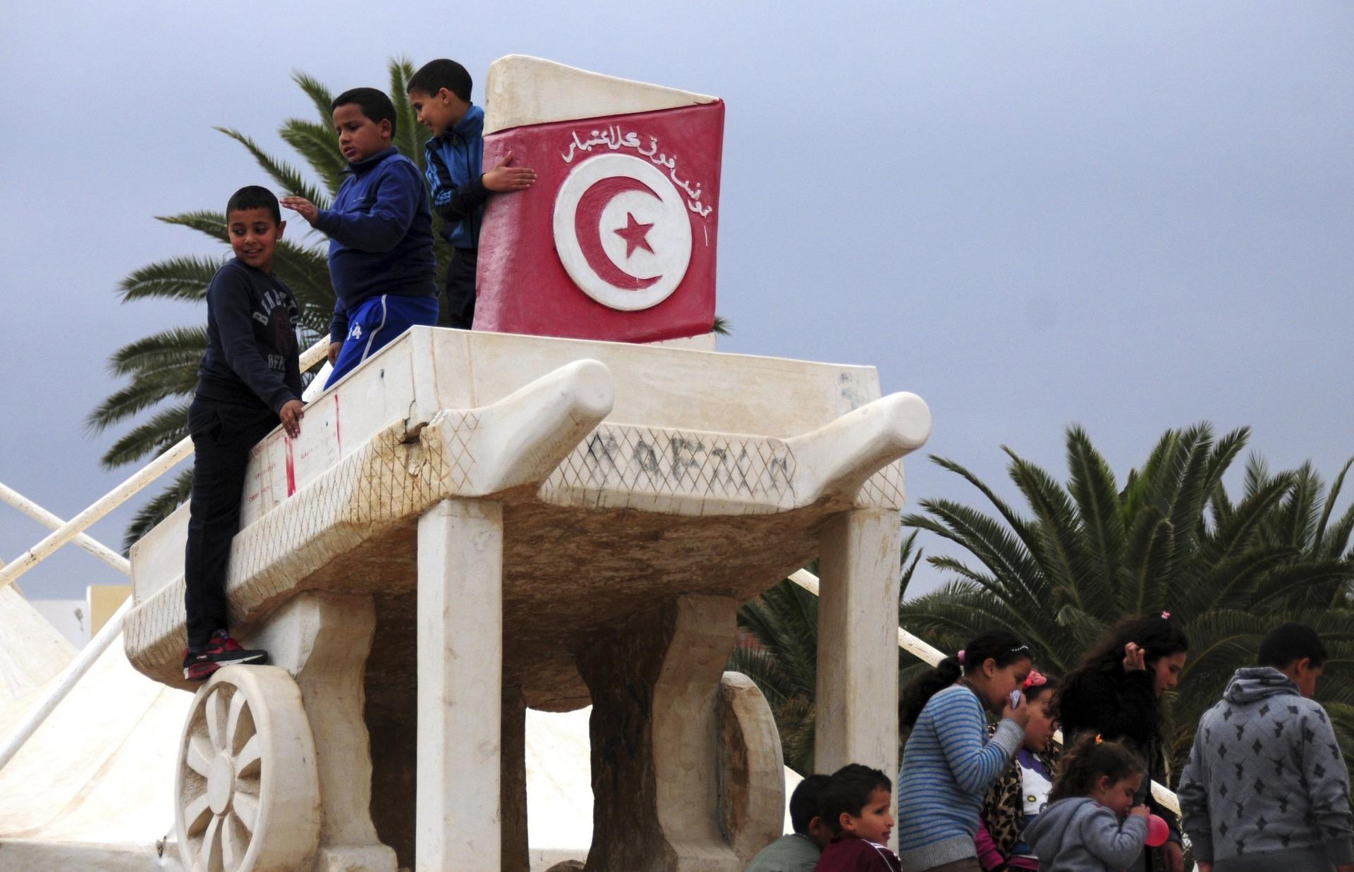 Children play on a statue of a wooden cart like that used by Mohamed Bouazizi to sell fruits, in Sidi Bouzid, Tunisia, Dec.17, 2015. Tunisians who won the Nobel Peace Prize joined townspeople in the country's beleaguered heartland to mark five years since
