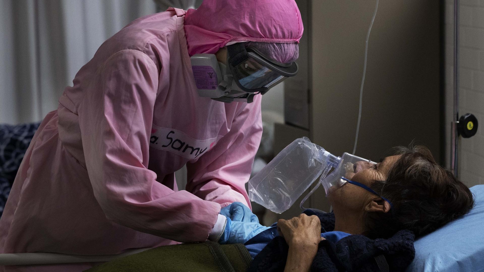 Dressed in protective gear to curb the spread of the new coronavirus, a medical worker massages a patient, at a military hospital set up to take care of COVID-19 patients.