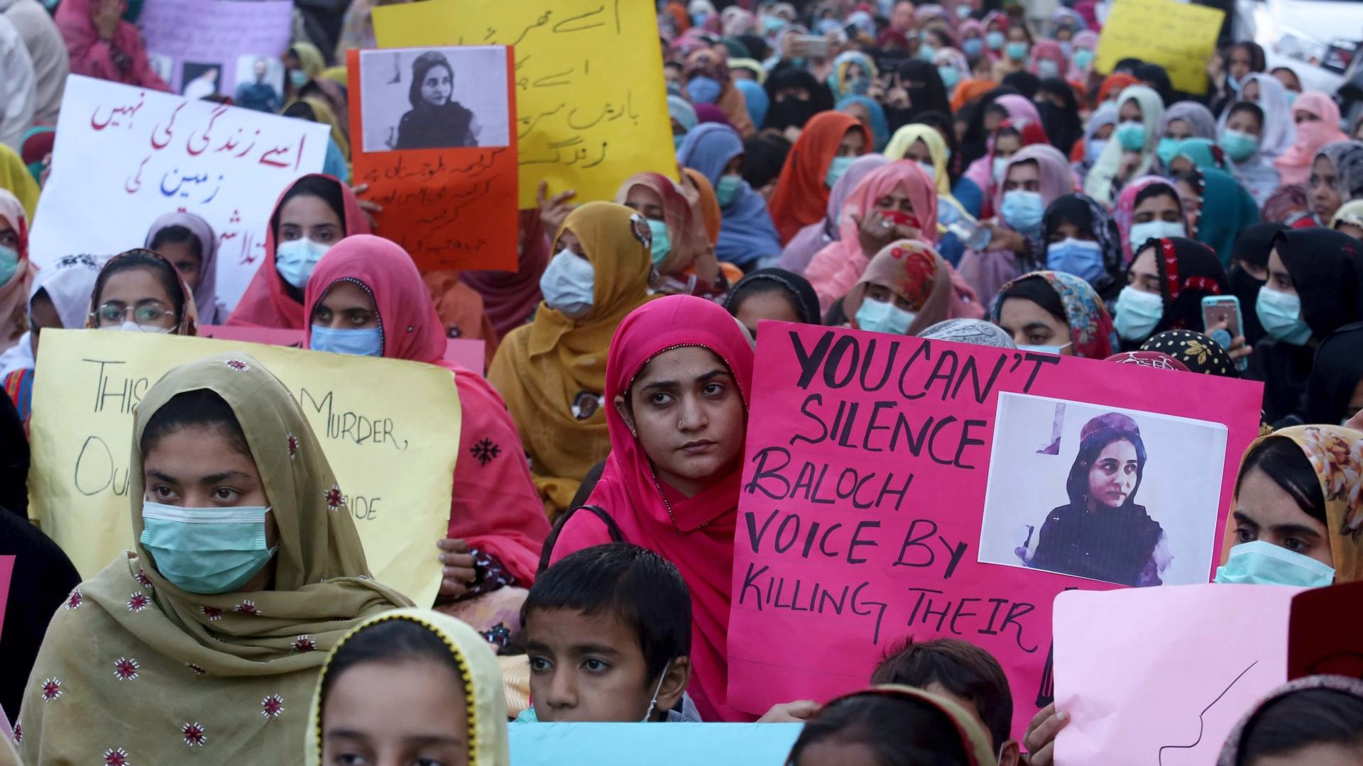 A massive protest of women wearing colorful head wraps and masks with signs supporting Karima Mehrab Baloch. 