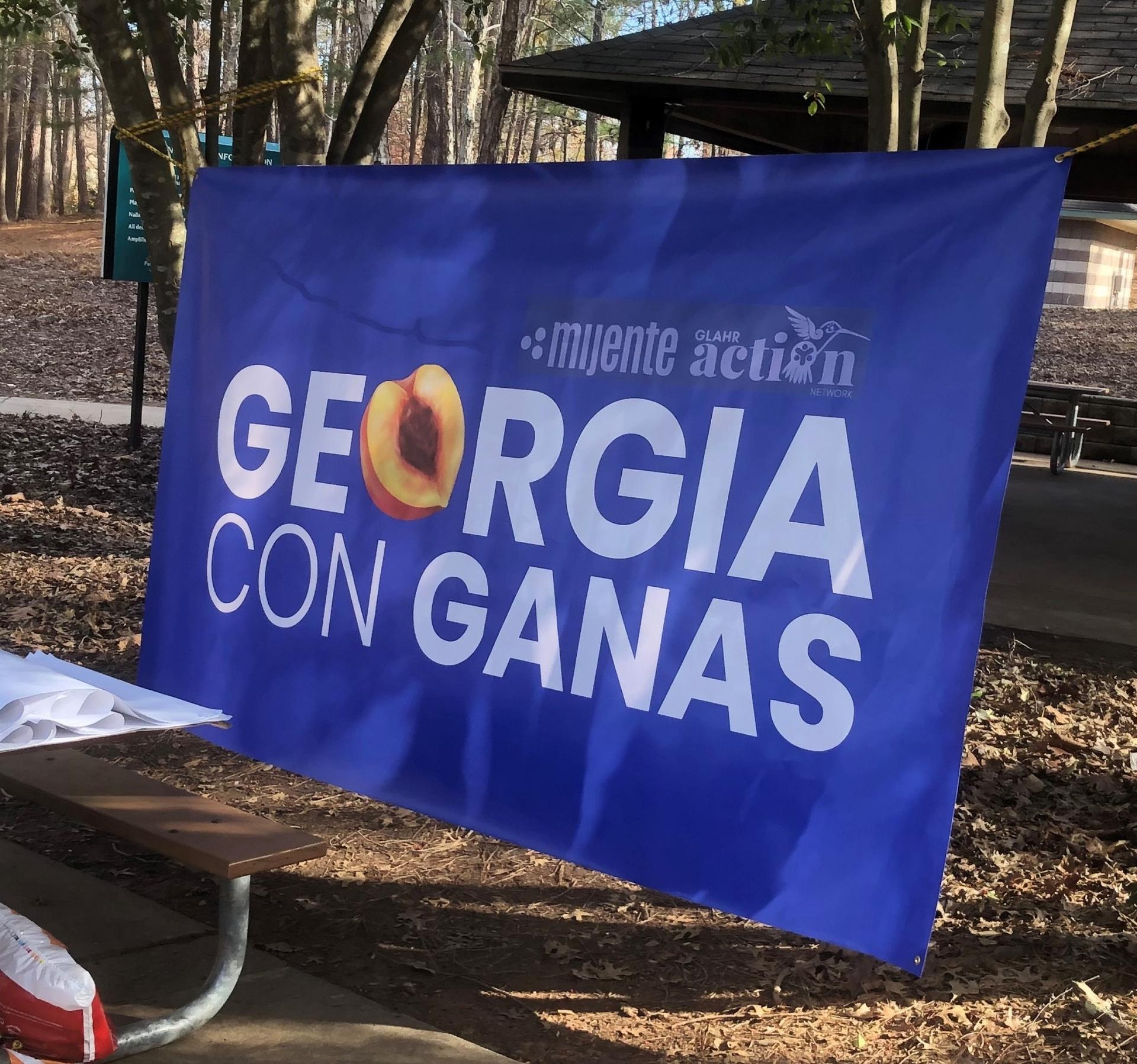 A blue sign with white letters says "Georgia con ganas."