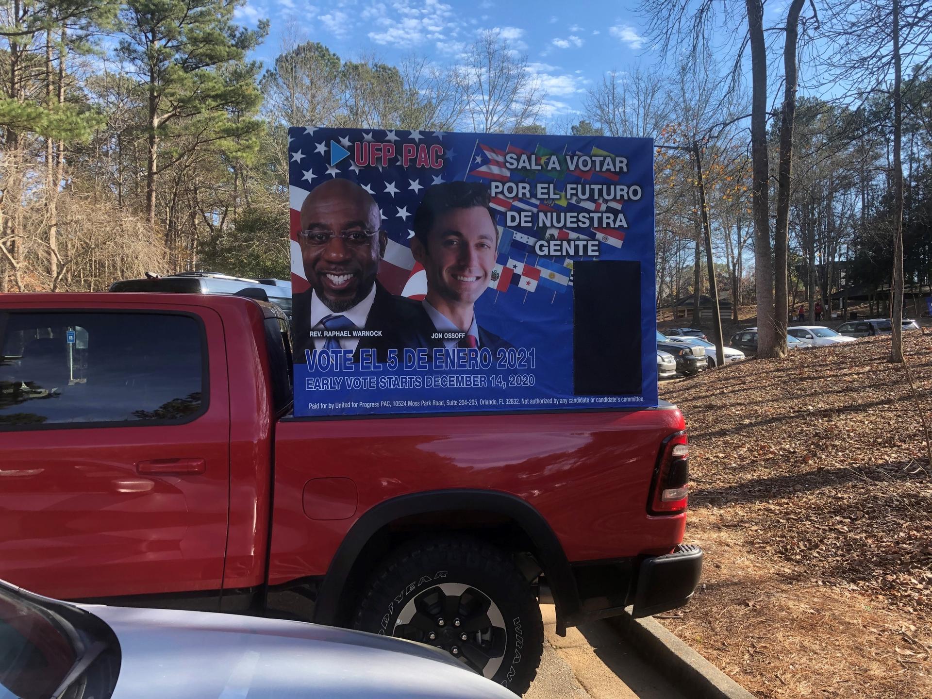 A red campaign truck features candidates Rev. Raphael Warnock and Jon Ossoff. 