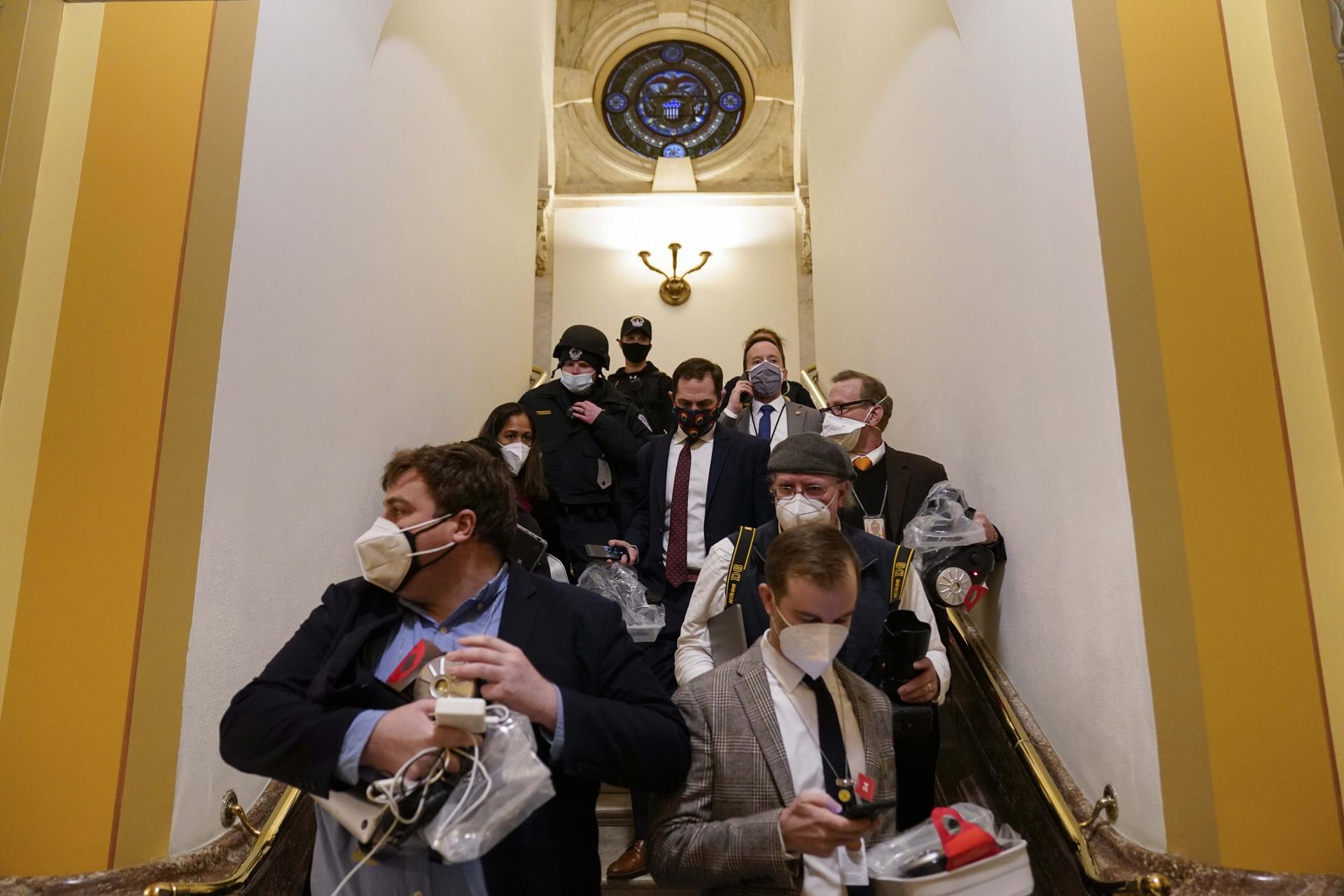 People evacuate from the House chamber as a violent mob of Trump supporters try to break in at the US Capitol on Wednesday, Jan. 6, 2021, in Washington, DC. 